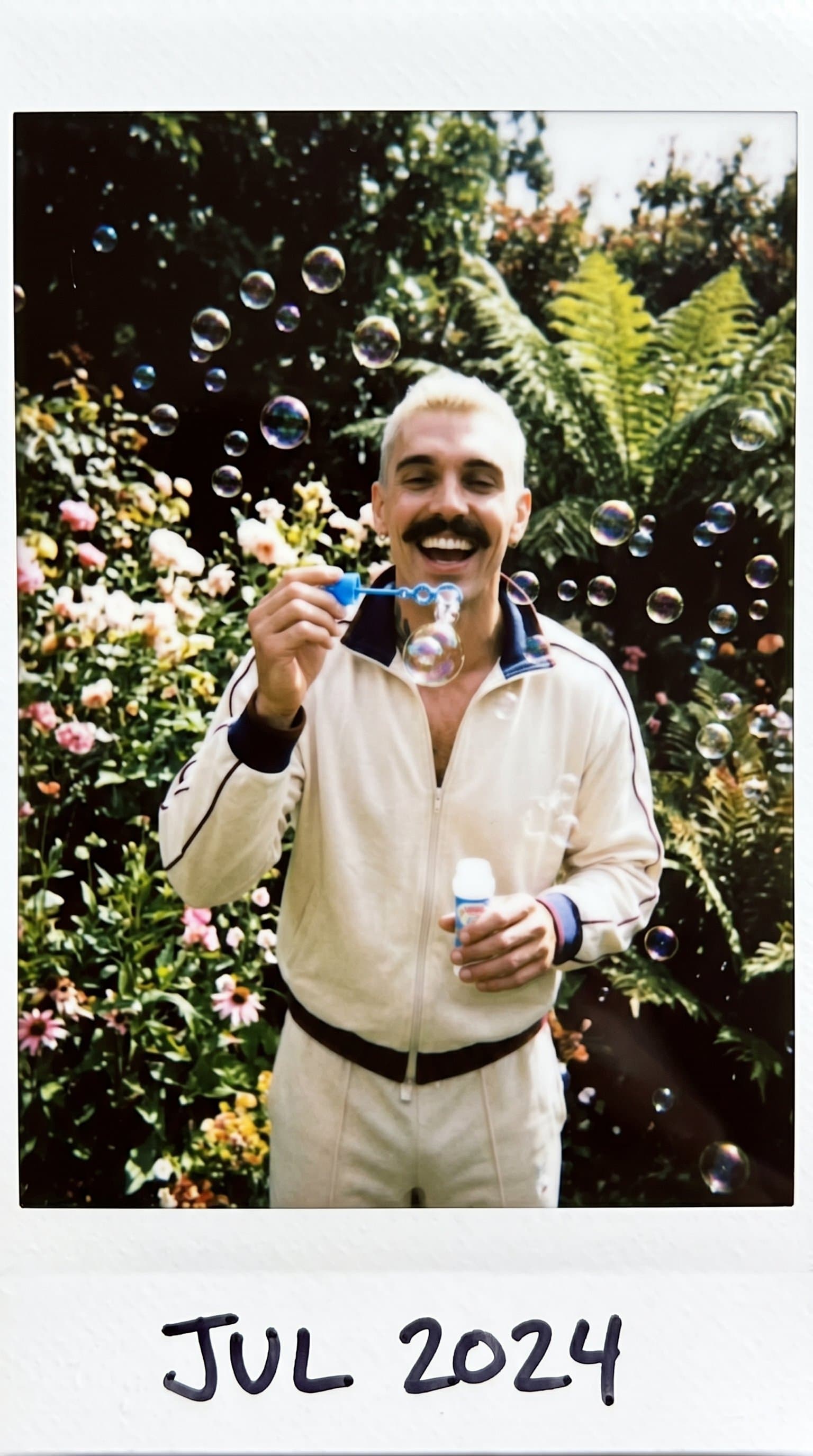 man blowing bubbles in a lush garden, Candid Insta
