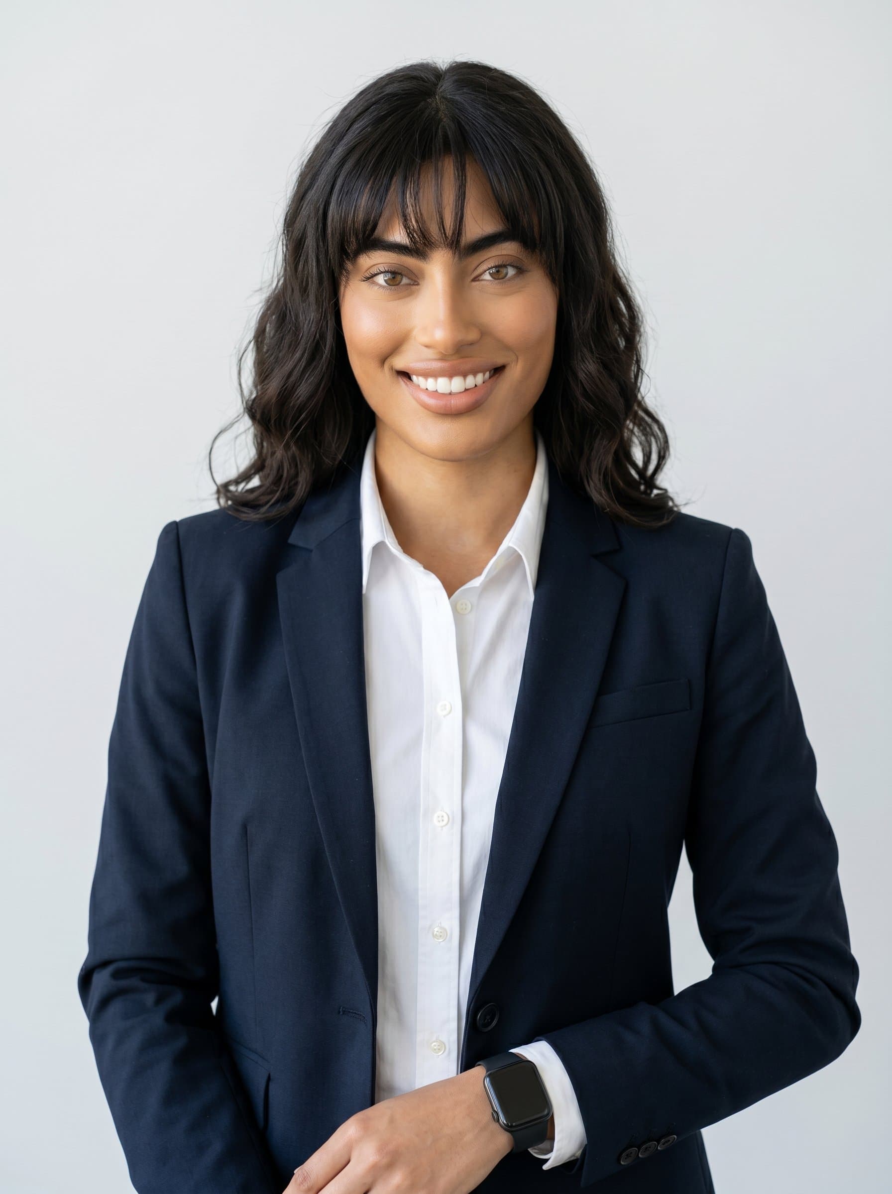 in a sleek business suit with a digital watch, confident expression, bright lighting, seamless light grey background, enhancing digital tech industry profile. Photorealistic headshot emphasizing professionalism and executive presence.