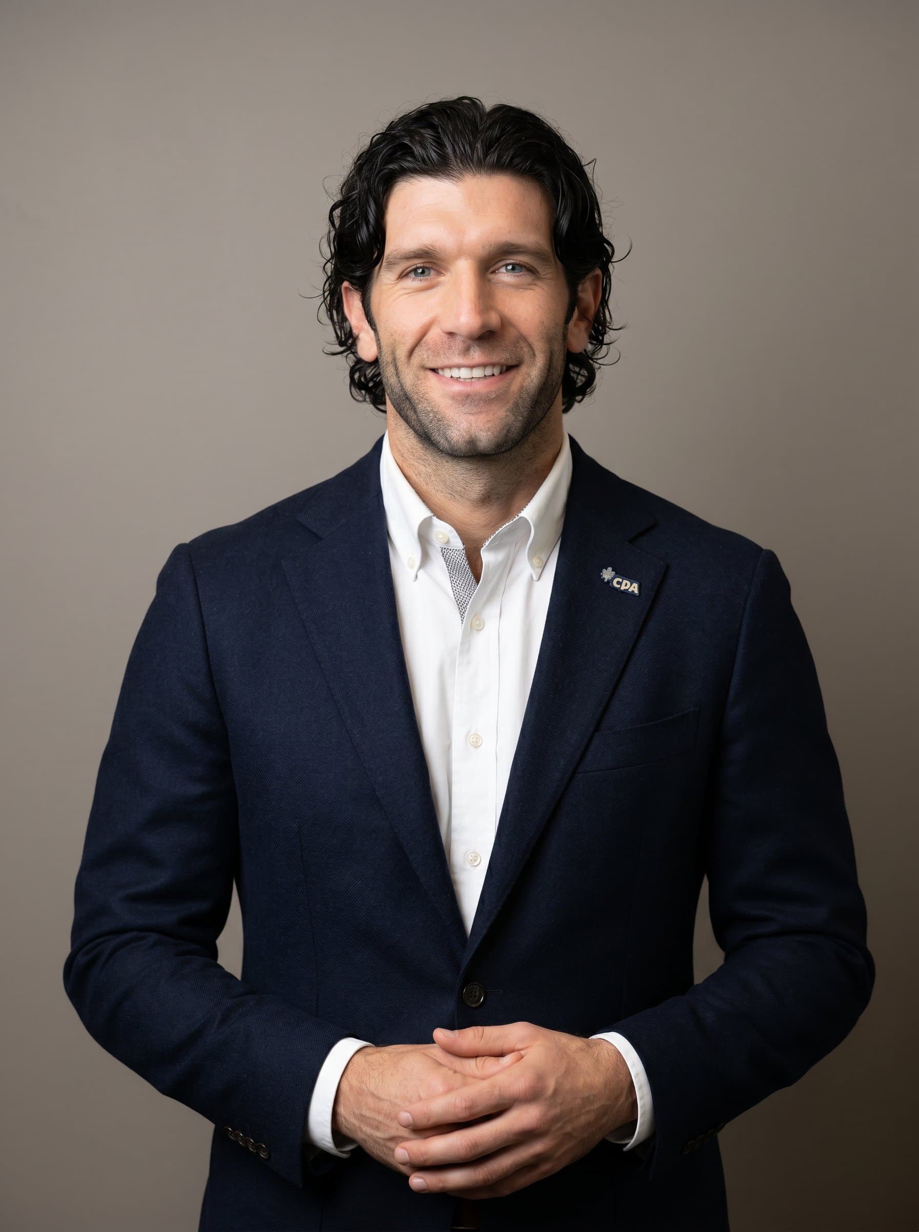 : Capture the professionalism of a CPA in a smart blazer and shirt, with a neutral backdrop. The image showcases a confident and trustworthy demeanor, essential for client reassurance.