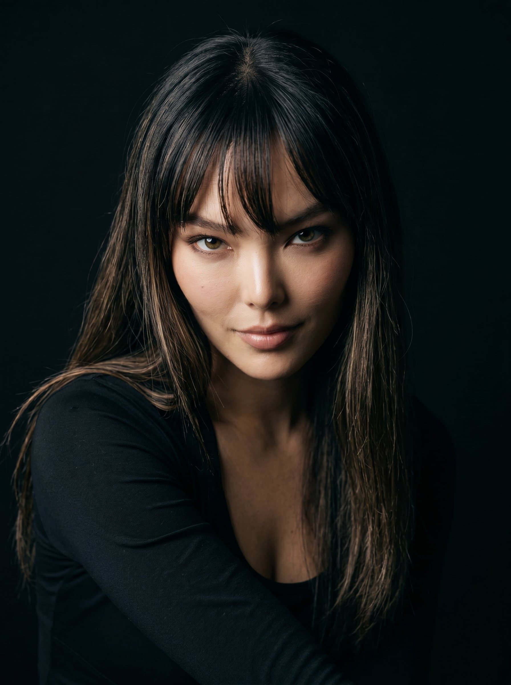 Capture Dramatic Impact in a headshot. The author exhibits a bold and intense look, with a dark, seamless backdrop that makes their eyes pop with intensity.