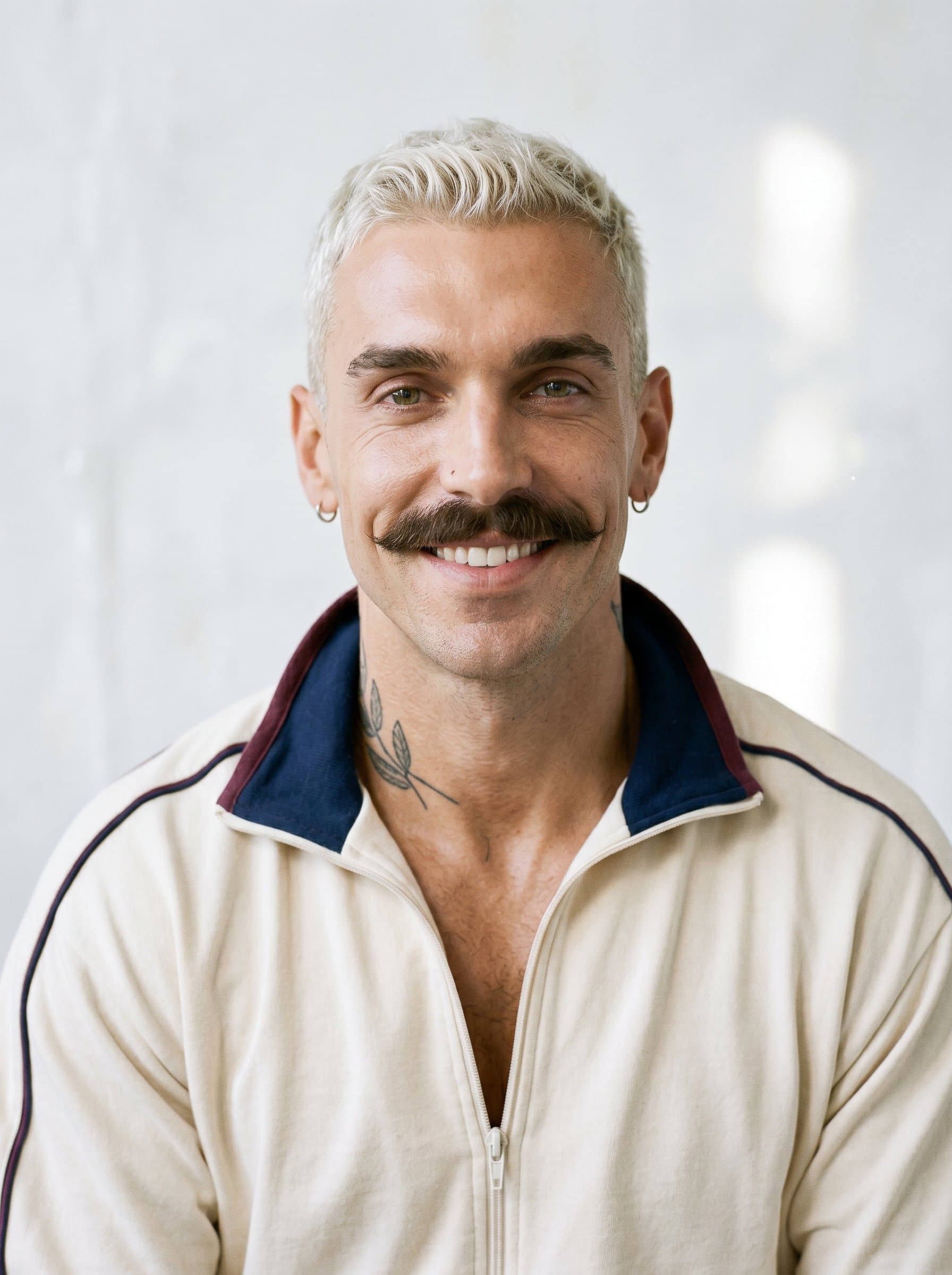 headshot for an author exuding Casual Confidence, with an easygoing smile. Background in soft white with a hint of texture keeps the focus on the man's relaxed demeanor.