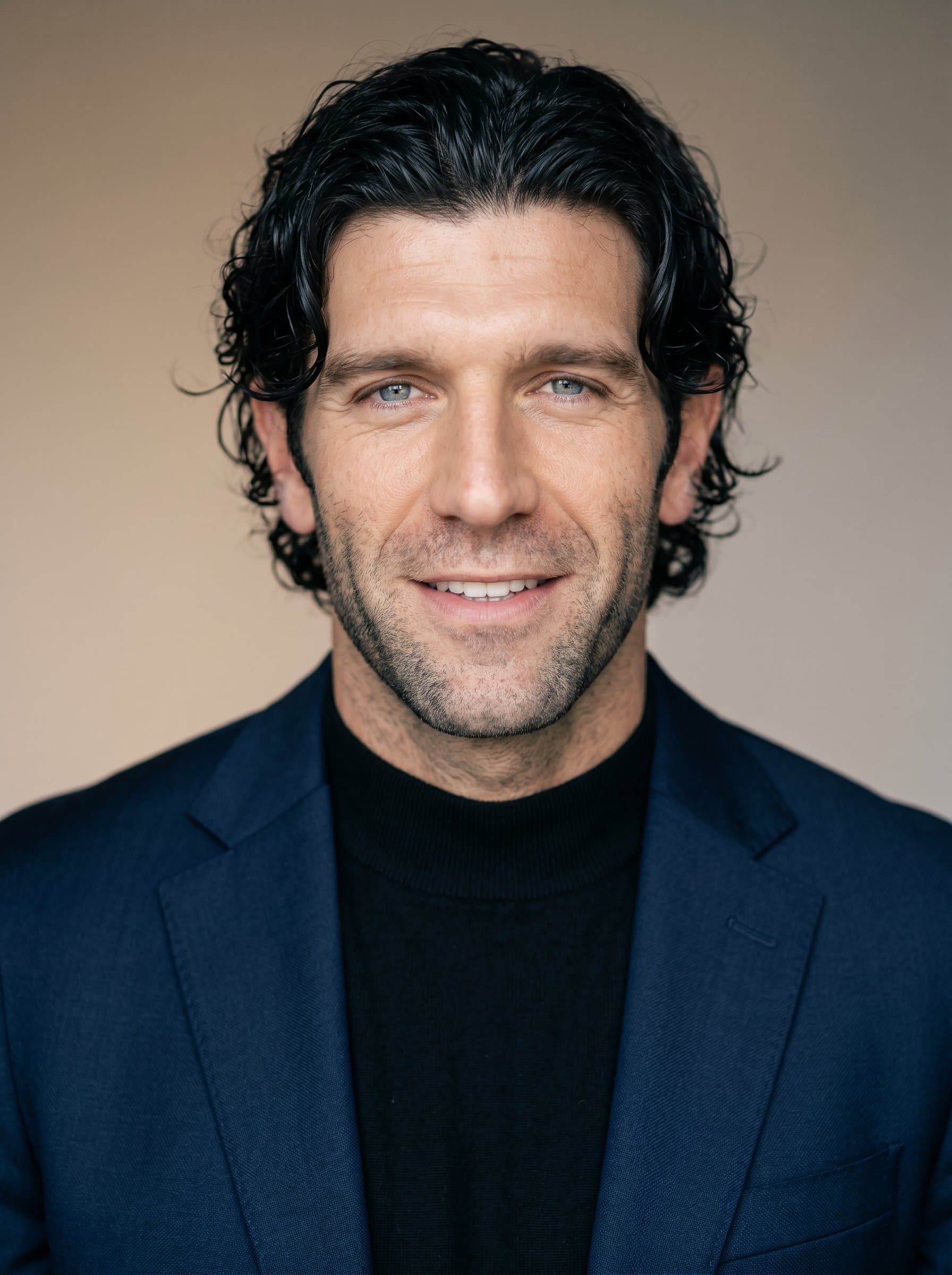 Modern Chic headshot capturing a confident author wearing contemporary attire. The background is a soft, neutral gradient, emphasizing clarity and style.
