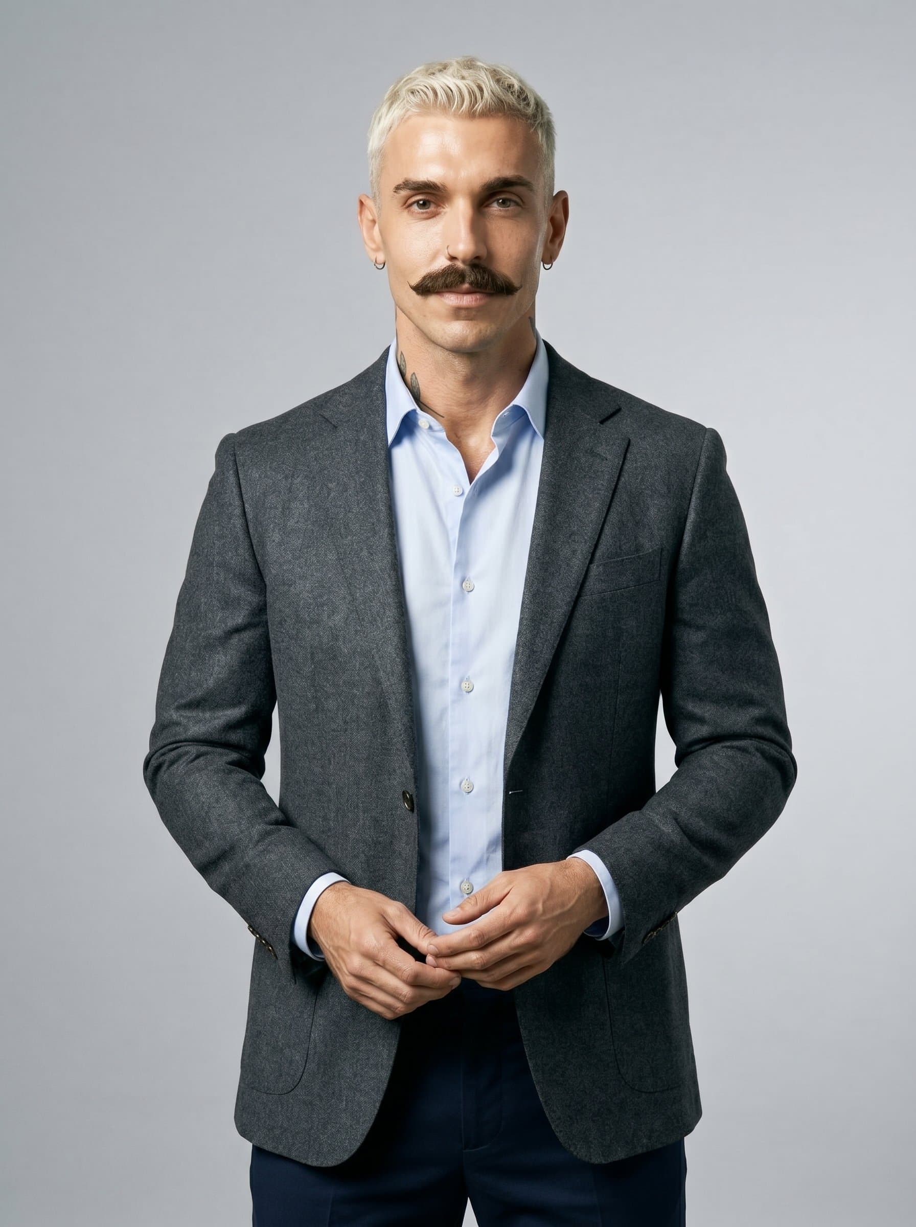 stands confidently against a light grey backdrop, sporting a tailored blazer with an open posture. The gentle lighting accentuates a thoughtful expression, conveying empathy and professionalism for a psychiatric expert.
