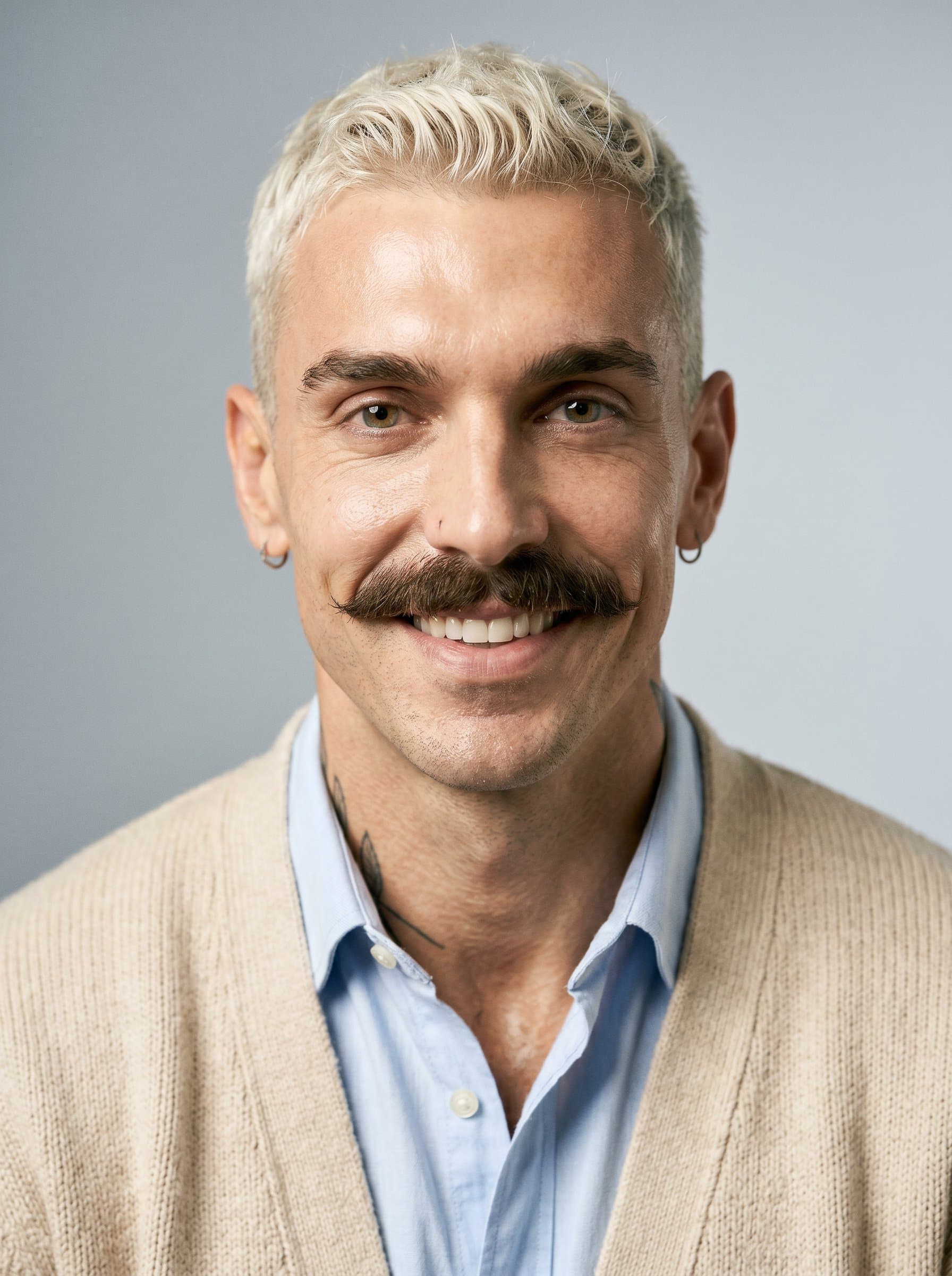 In a light cardigan, 's headshot emphasizes approachability. The neutral-toned background focuses on their open and expressive face, ideal for building rapport with a wide range of news sources and audiences.