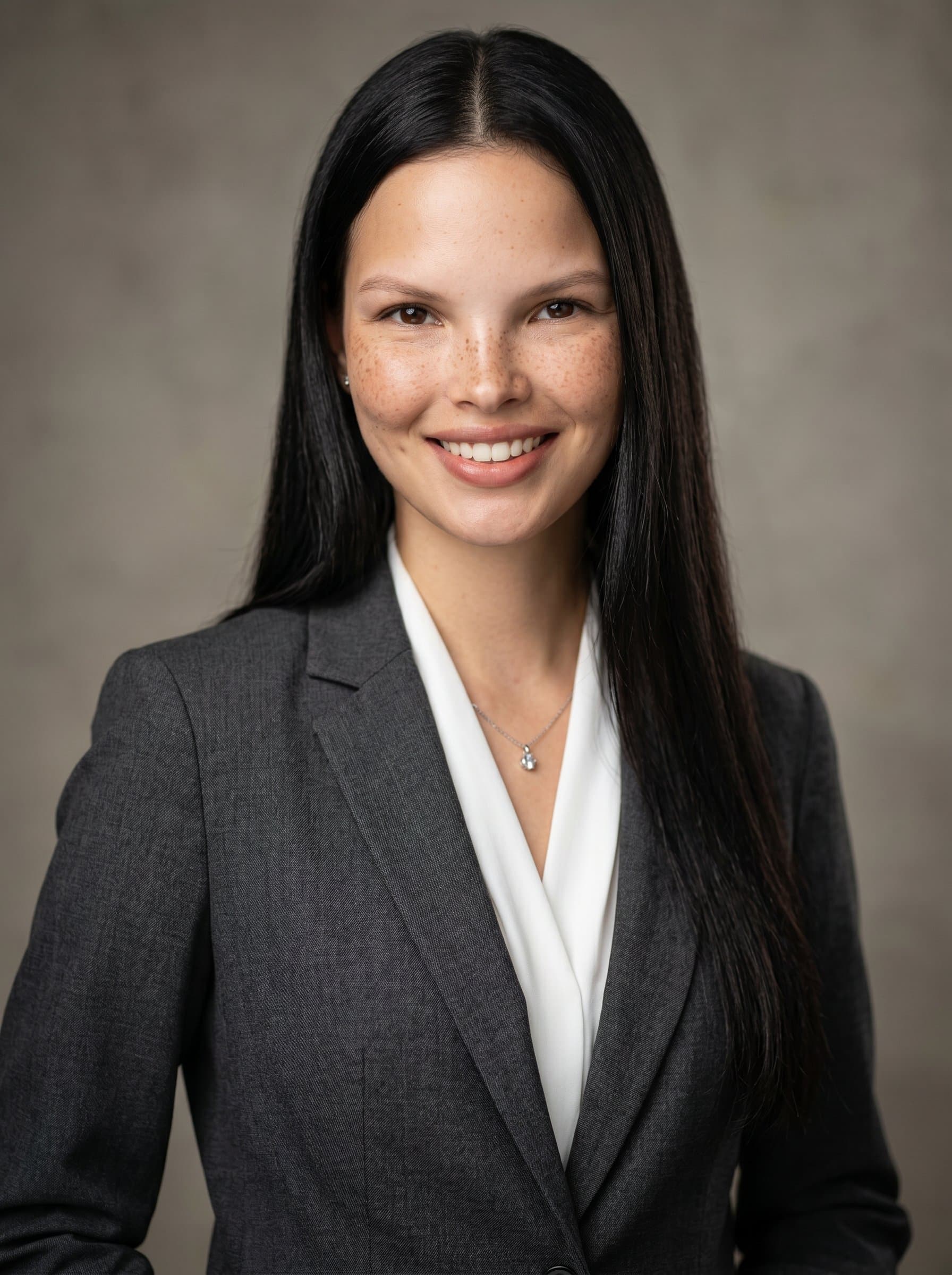 in a neat suit, posed with confidence. A neutral backdrop and expertly placed lighting emphasize facial features, delivering an approachable and photorealistic headshot for news broadcasting.