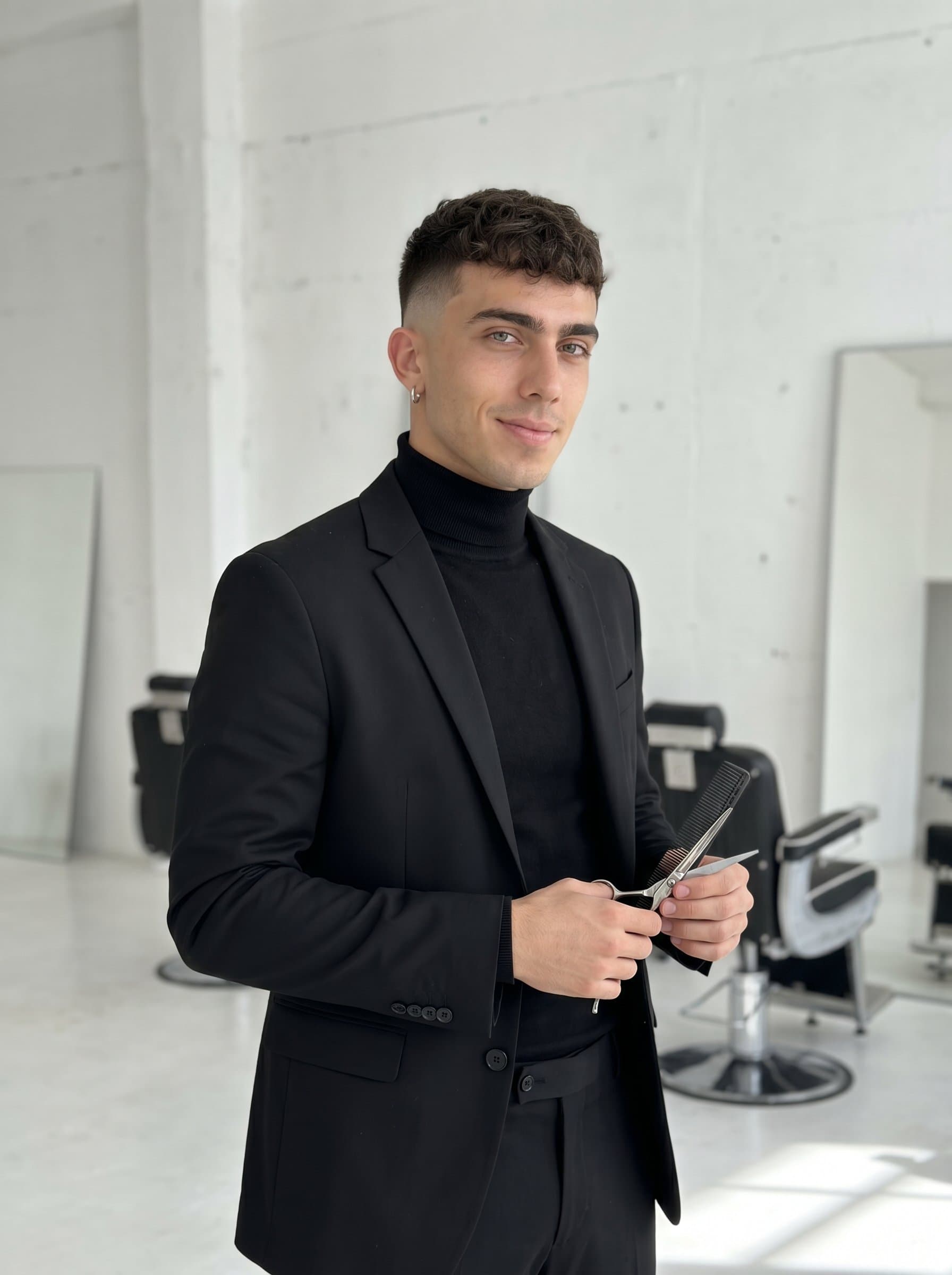 Modern barber portrait with a fade haircut, styled in a sleek, monochromatic outfit, set against a minimalist, bright background, emphasizing contemporary fashion and fresh grooming techniques.