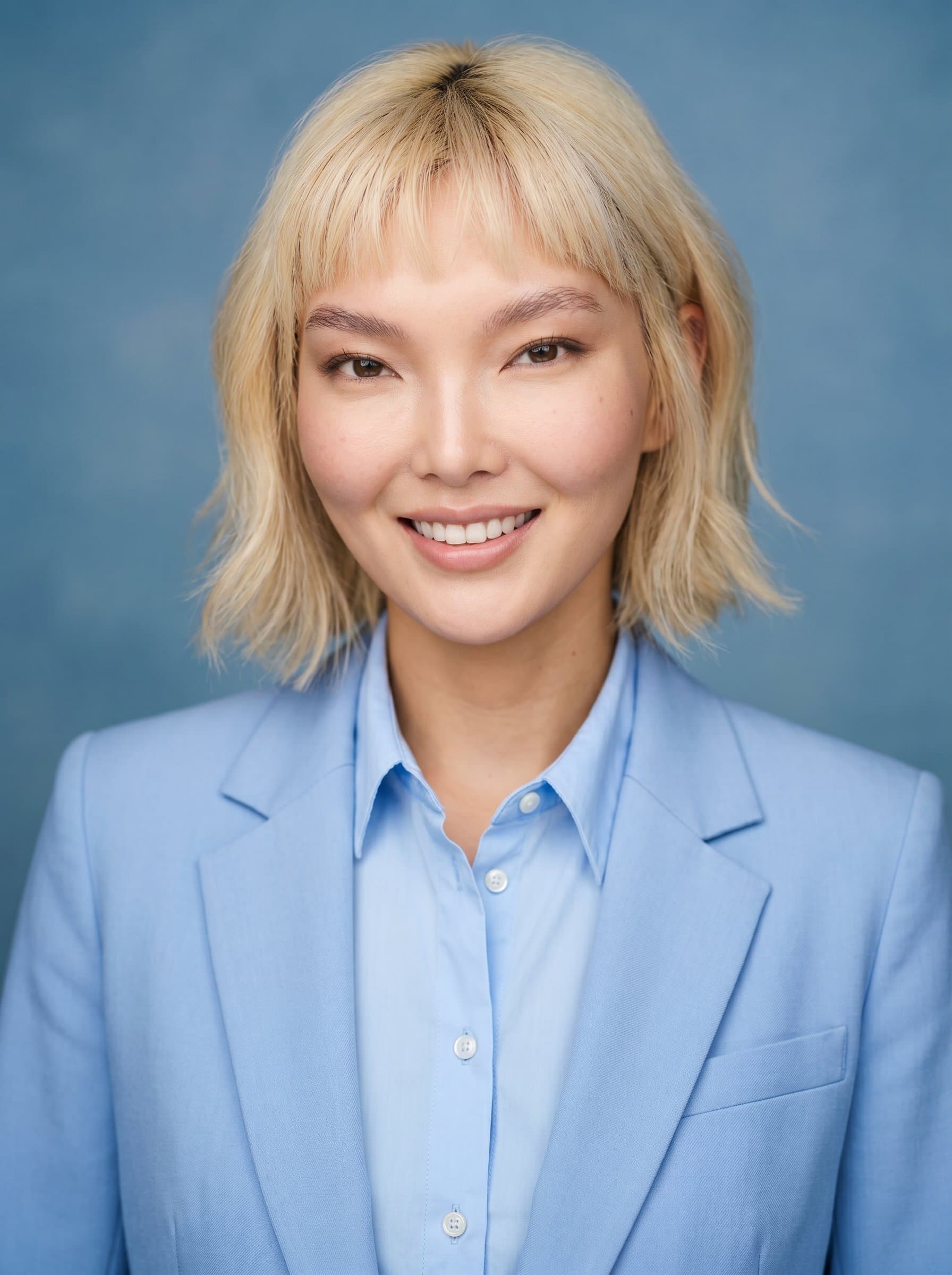 Against a soothing blue backdrop, wearing a professional dress shirt, offers a reassuring yet confident expression, perfect for creating a positive impression on medical residency applications.