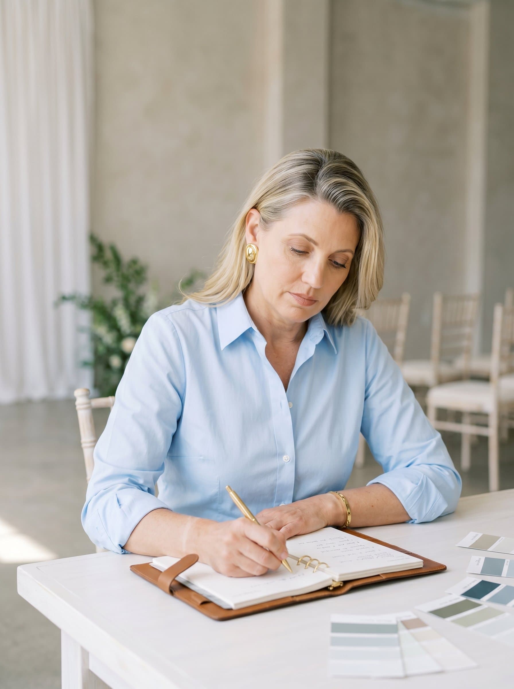 Create a of a wedding planner wearing a crisp collared shirt, jotting down notes. The background should be elegantly simple, ensuring focus remains on their dedicated and professional demeanor.