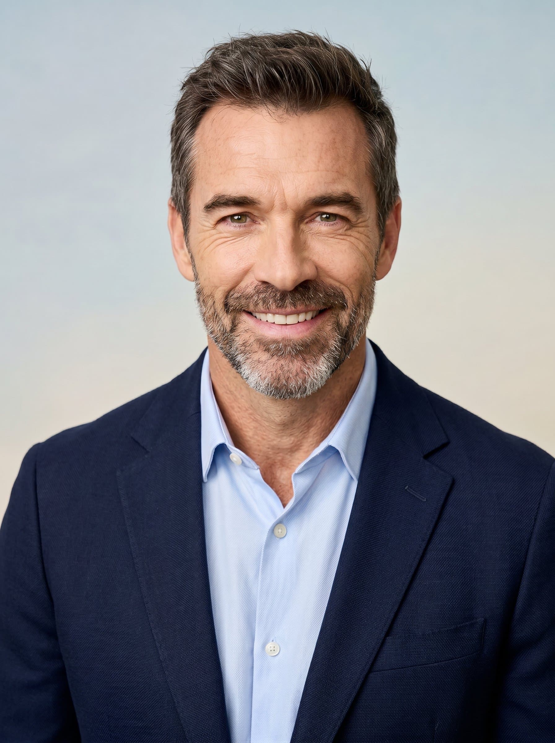 The headshot features in smart casual attire, set against a gentle gradient background. Their warm, engaging eyes and approachable expression reflect a commitment to fostering positive educational environments.