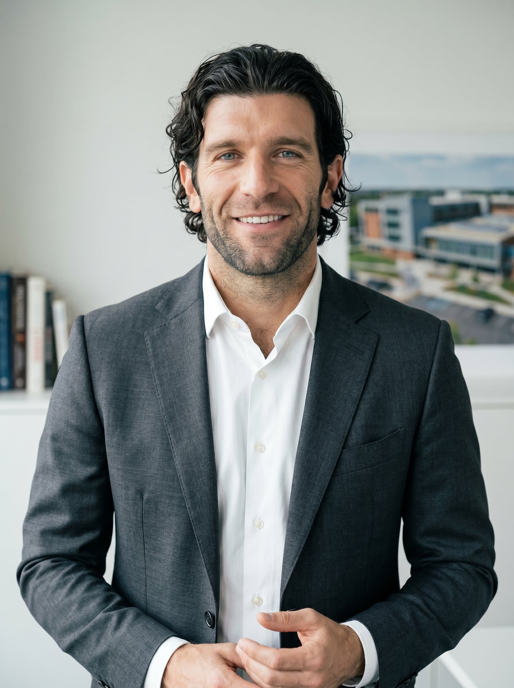 's headshot features a clean, understated backdrop, matching their elegant, professional attire. Their friendly and confident expression conveys leadership and a deep commitment to educational progress.