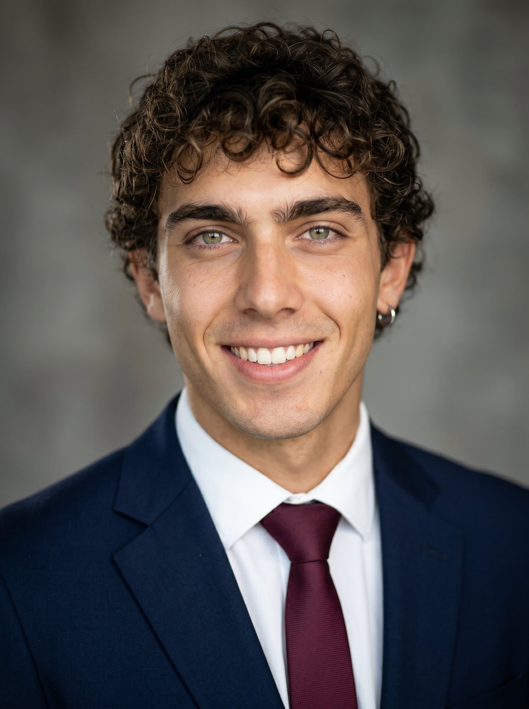 : Create a headshot showcasing charisma and accessibility, with soft lighting and a neutral backdrop to emphasize approachability, ideal for a politician's media appearances.