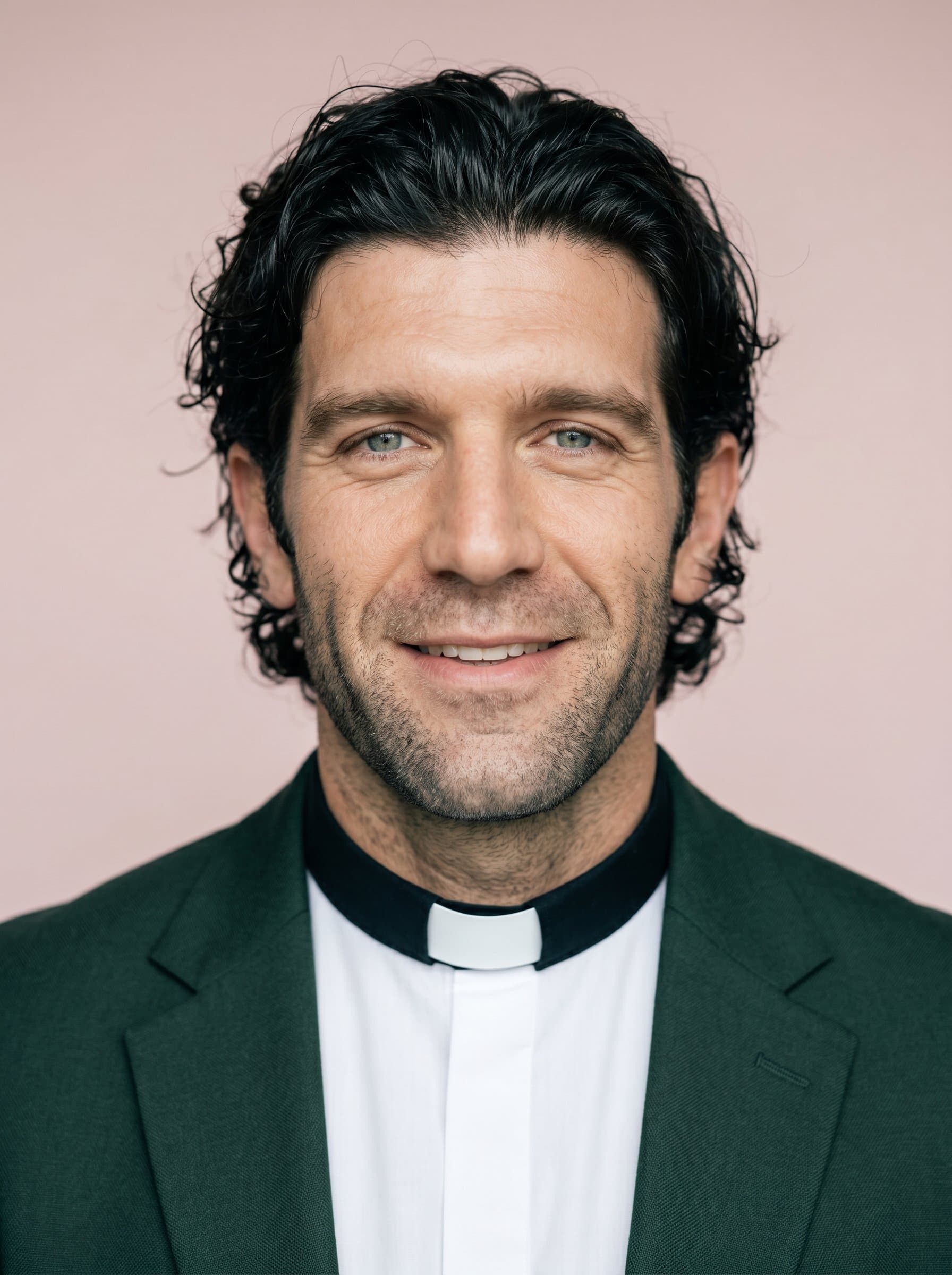 : Capture a pastor's headshot with a warm and open gaze, in a smart dark green blazer, with a subdued pale pink background, symbolizing faith, hope, and unity.