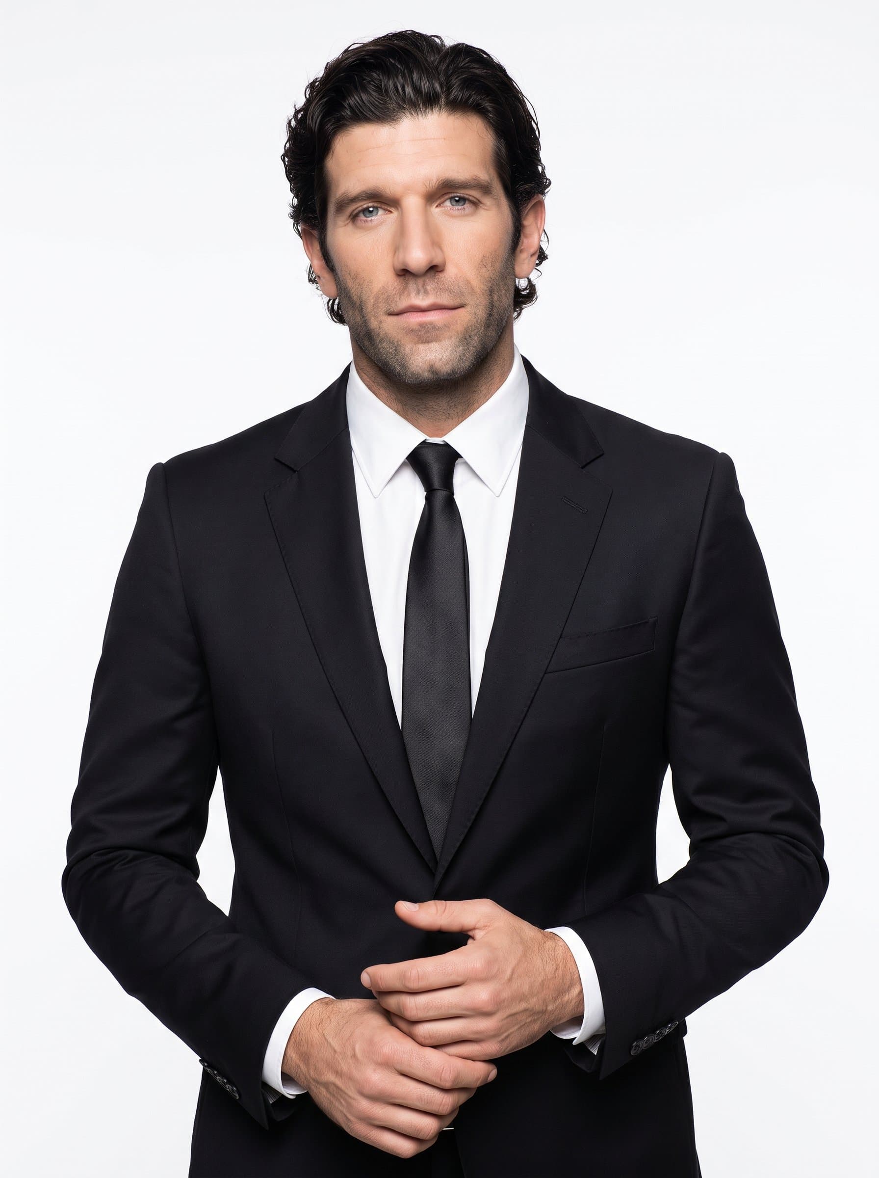 of a legal professional in a fitted black blazer, posing with a calm and collected demeanor, hands gently clasped, set against a seamless white background.