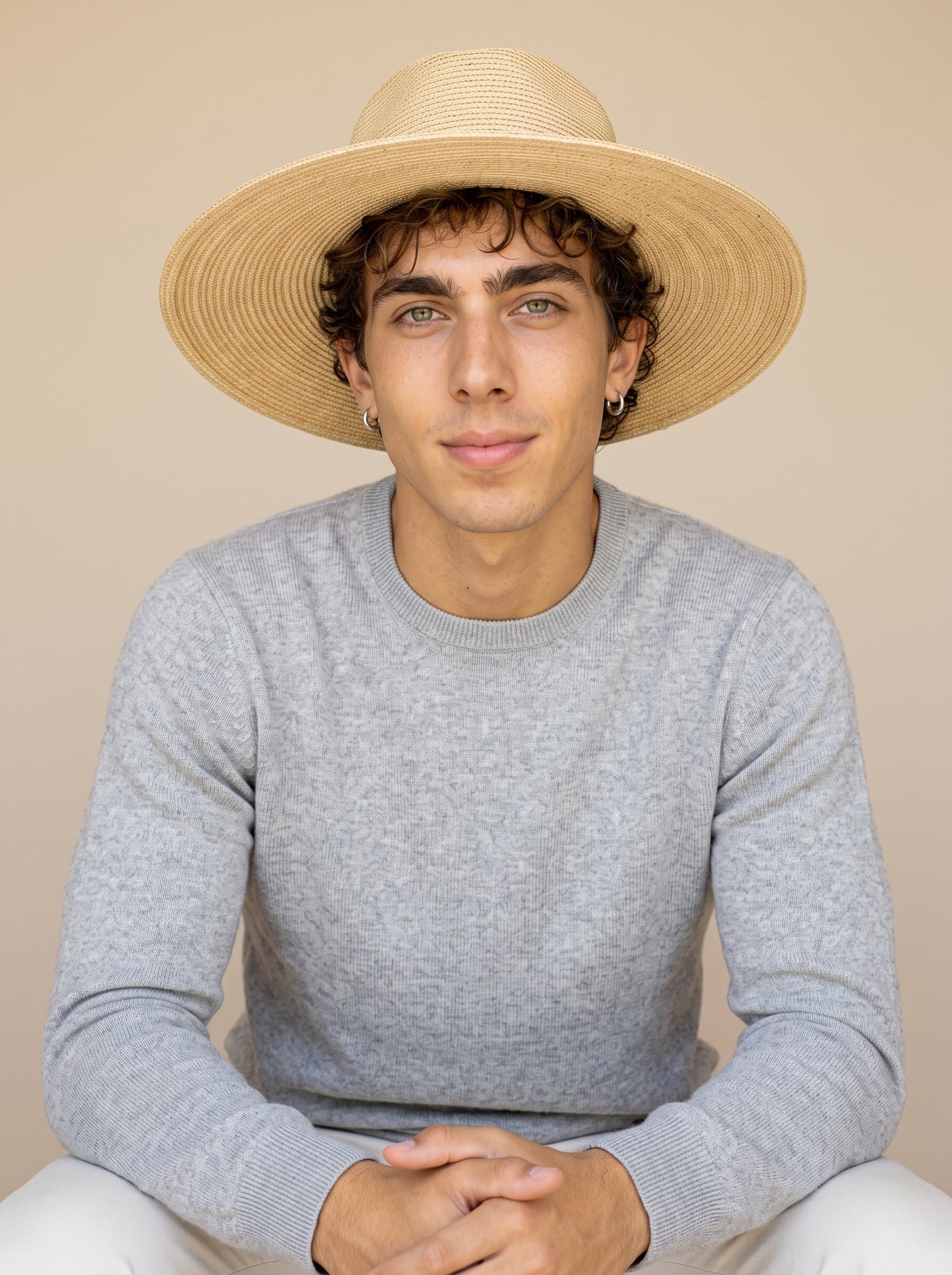in a relaxed pose, wearing a neat sweater. The background is a calm, neutral shade, highlighting the man’s trustworthy nature.