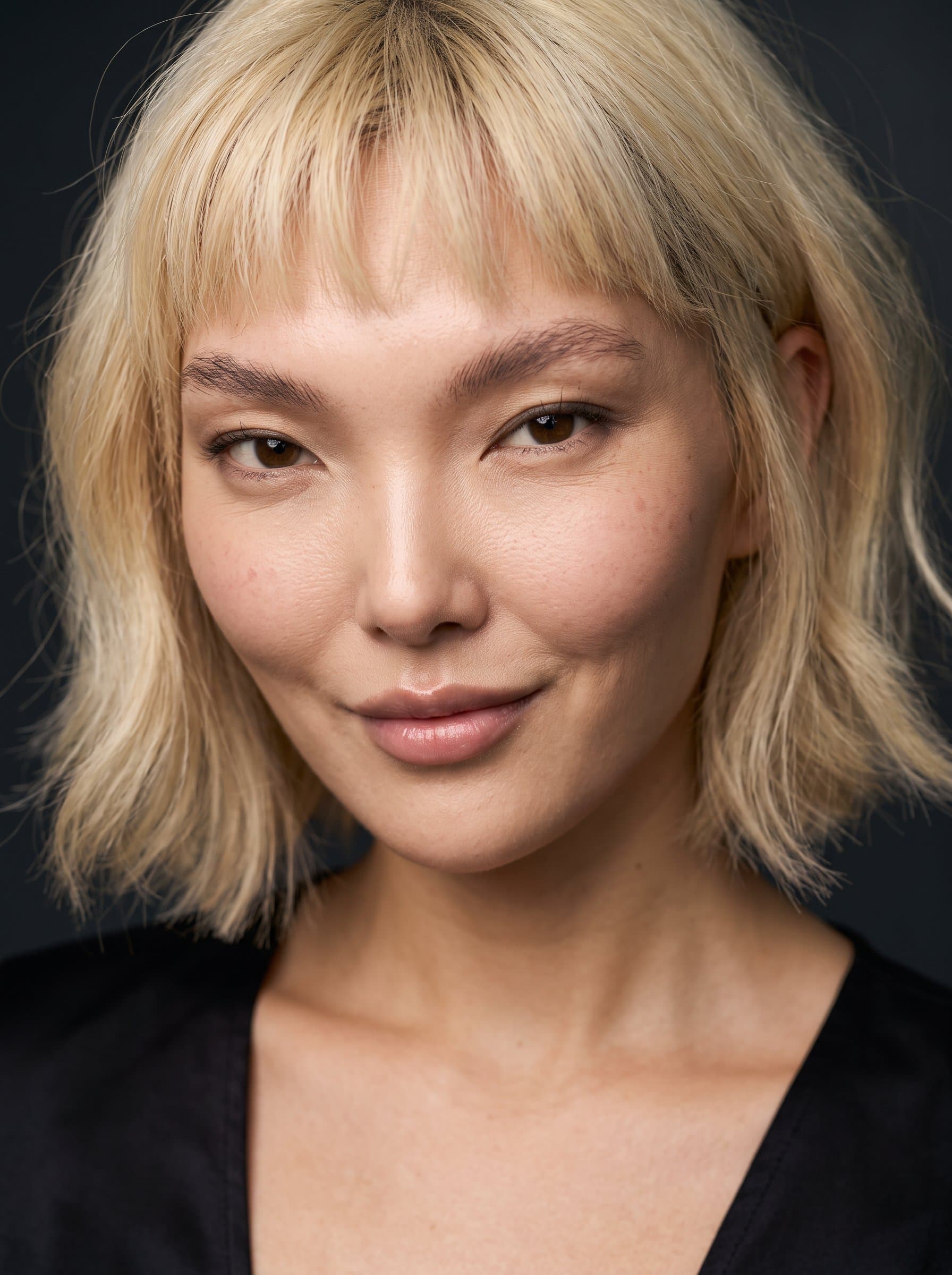 : Capture an enigmatic smile that teases mystery, with balanced lighting to highlight the lips and eyes against a simple background, suggesting intrigue and depth in character portrayal.