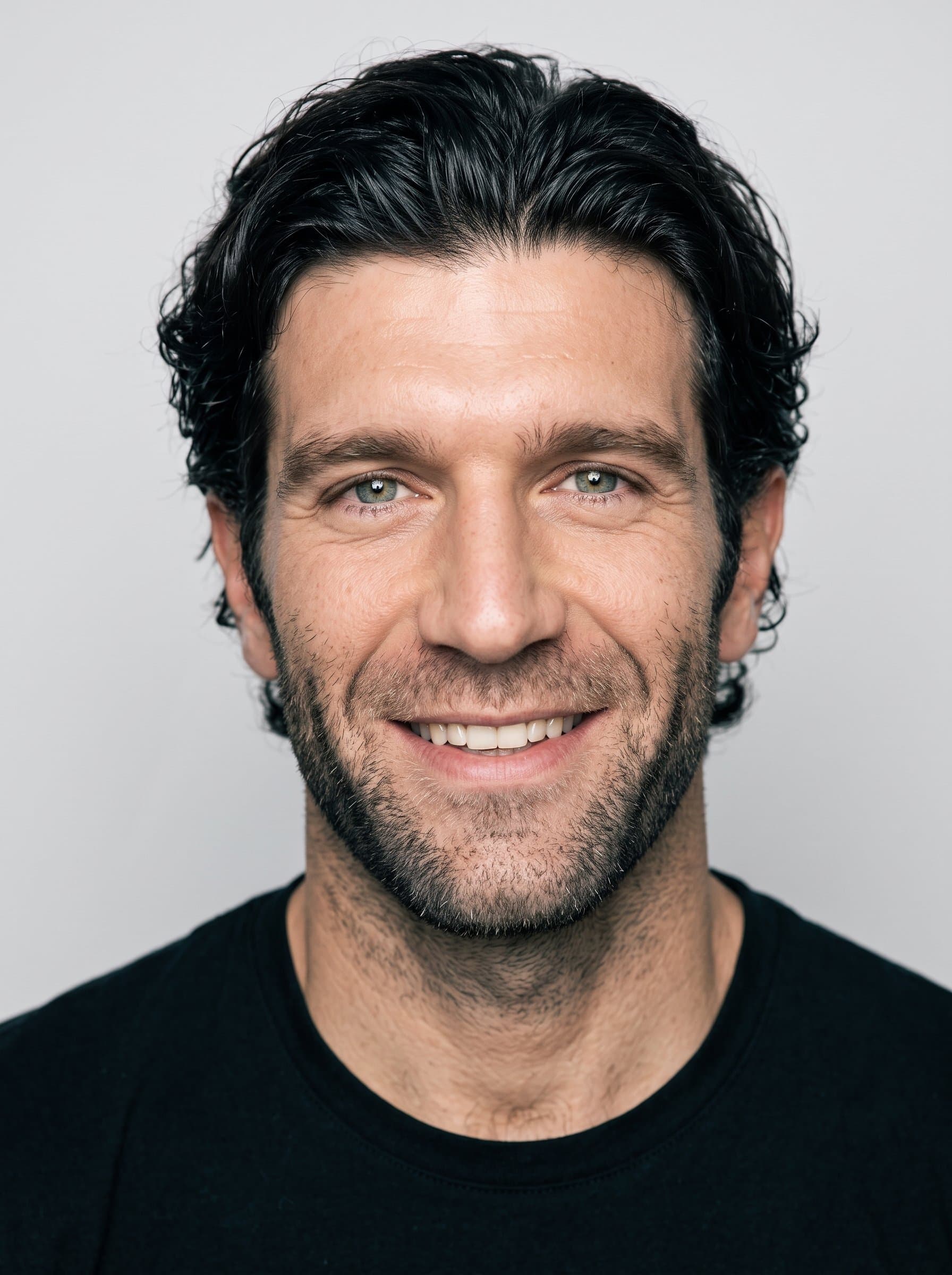 : Capture a lively, engaging expression with even lighting to soften facial features, set against a plain background to ensure all attention is on the actor's dynamic potential.