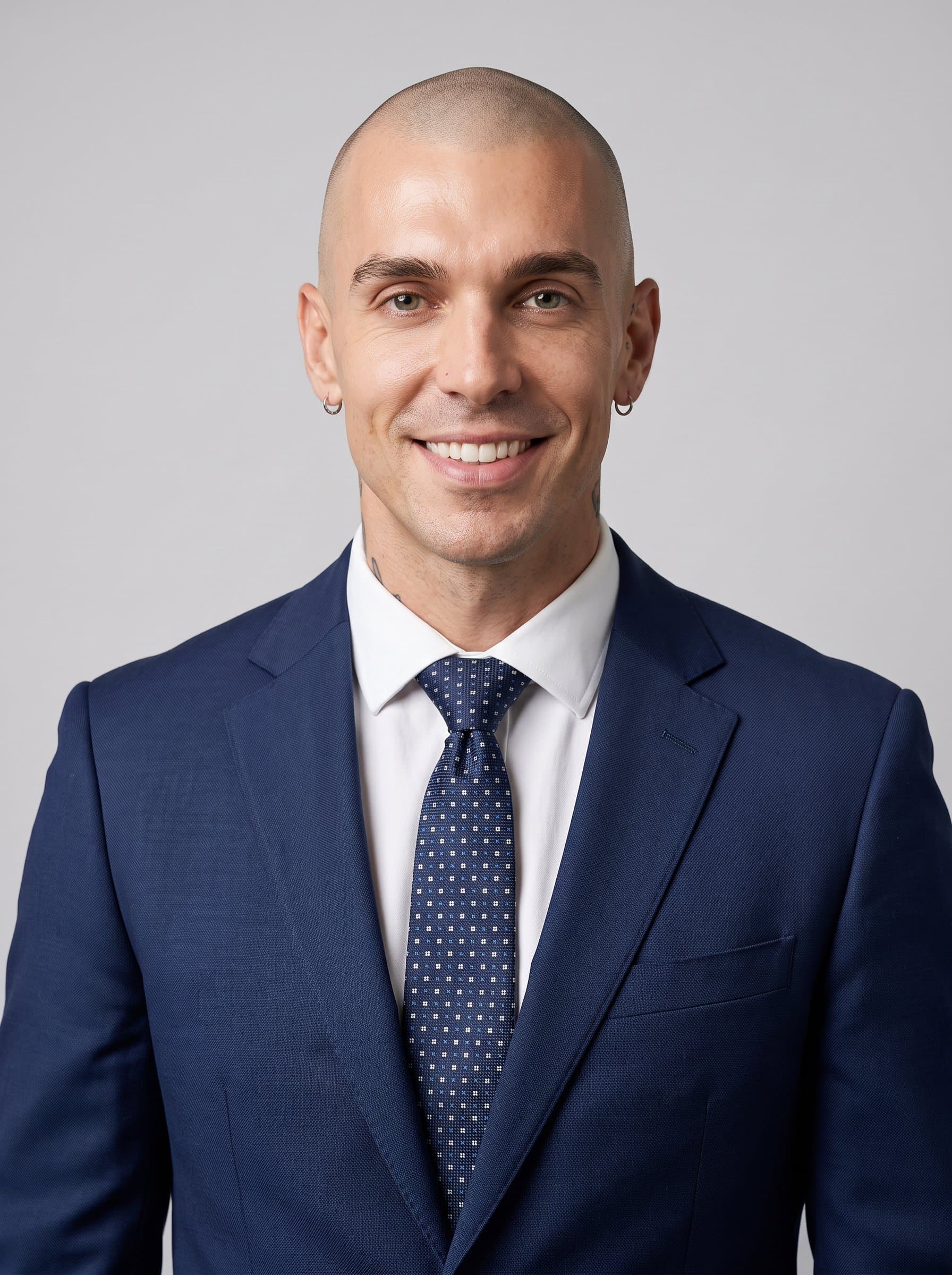 : AI-created photo of a consultant with a clean-shaven head, in a classic navy suit and patterned tie, captured with a soft light against a light gray background, conveying a professional and inviting demeanor.