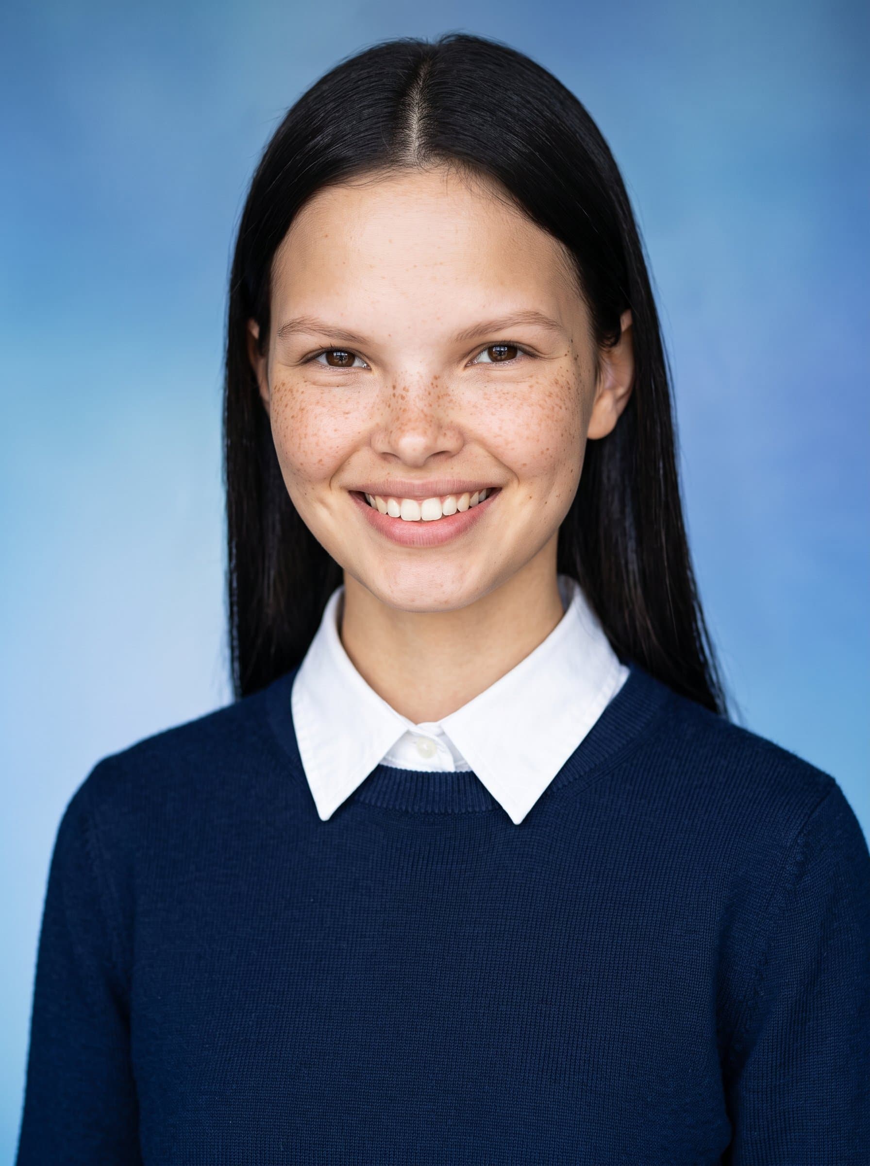 team member wearing a neat sweater over a collared shirt, exuding warmth. Background is a gradient of blue for a calm, professional tone, emphasizing approachability.
