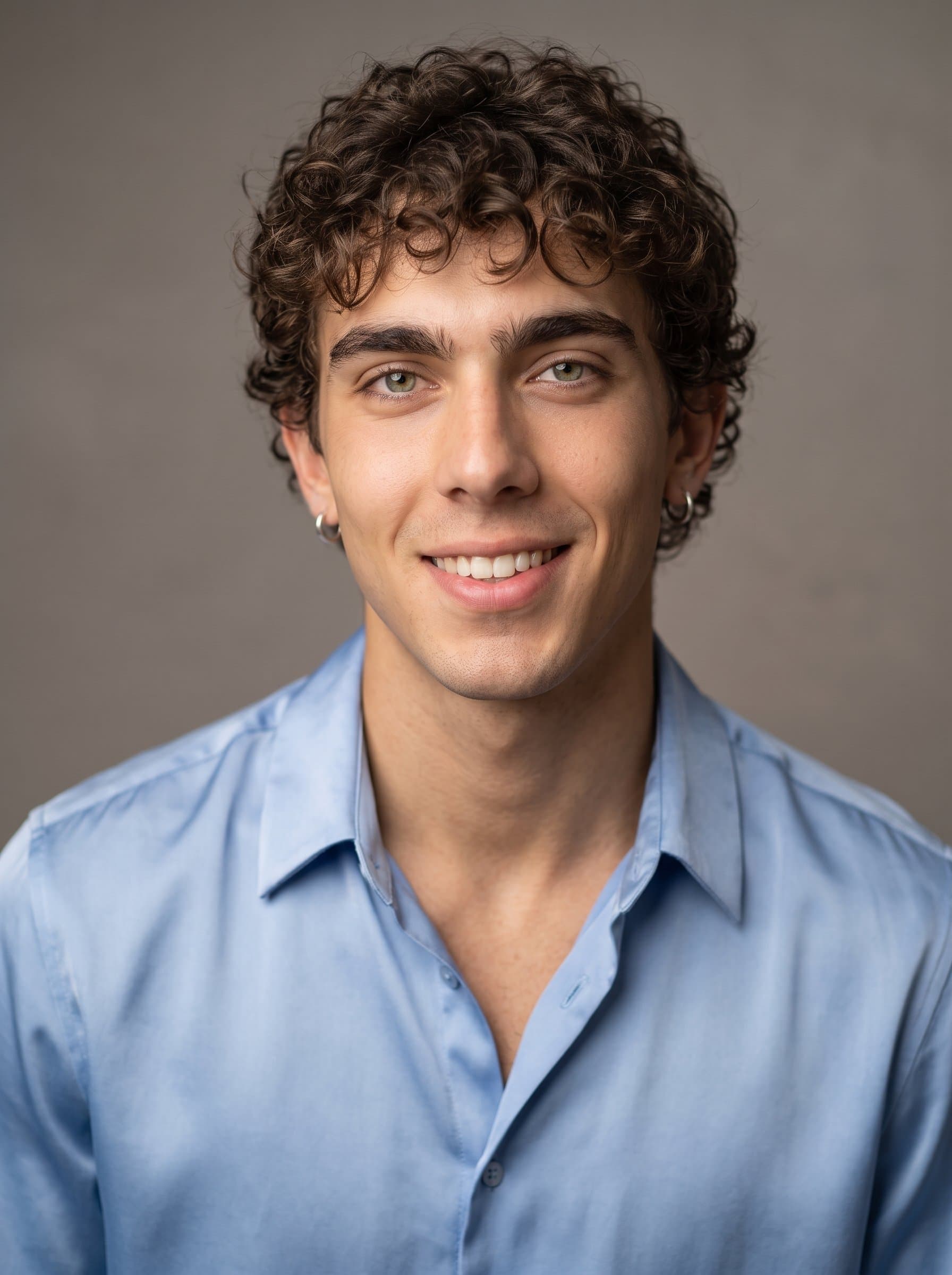 Design a professional retail headshot with presenting a smiling man in an elegant blouse, set against a neutral toned backdrop for a clean and customer-centered representation.