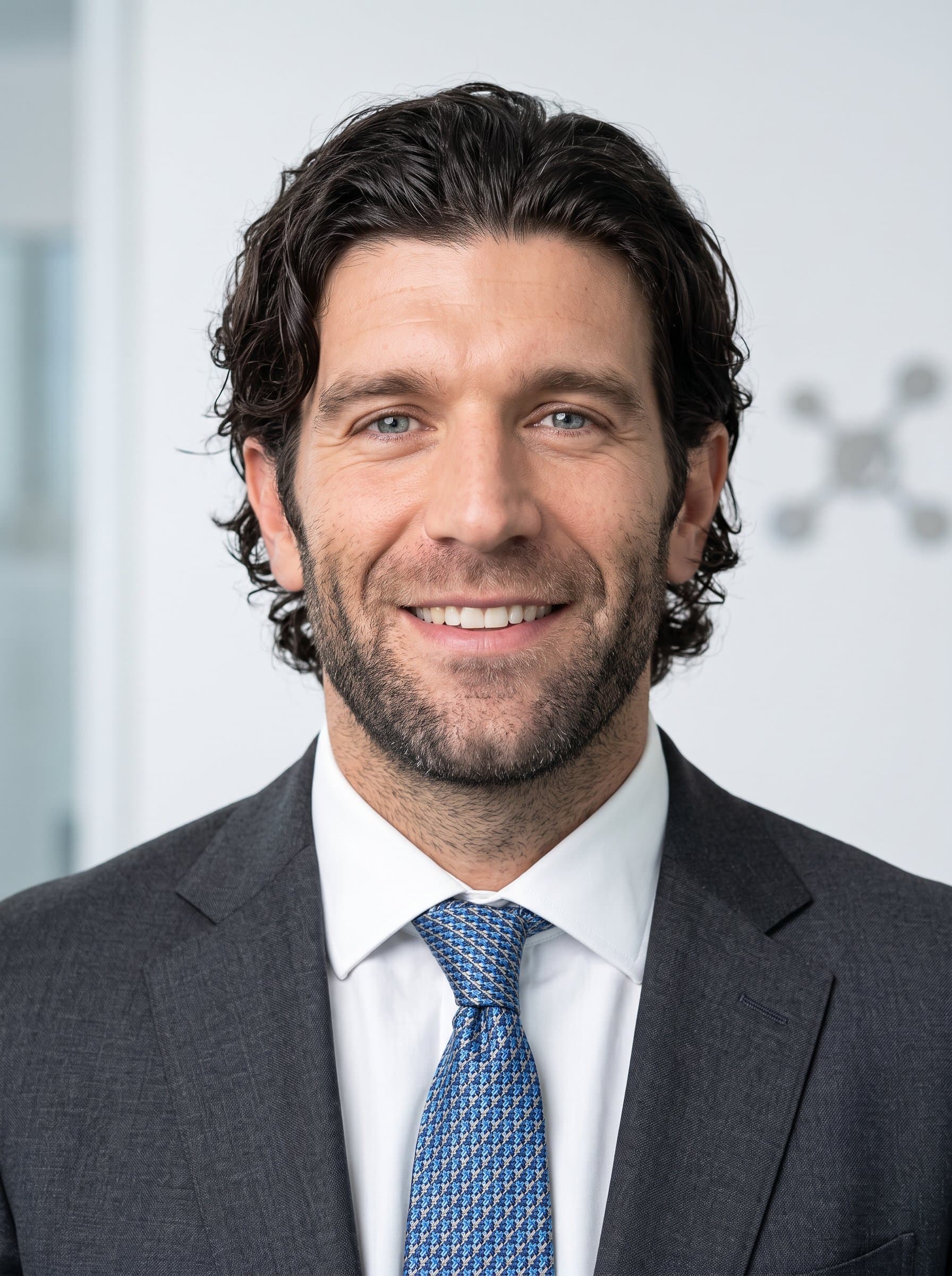 in a professional headshot, featuring smooth lighting that highlights their reassuring smile and business attire, set against a clean backdrop to accentuate their pharmaceutical expertise and dependability.