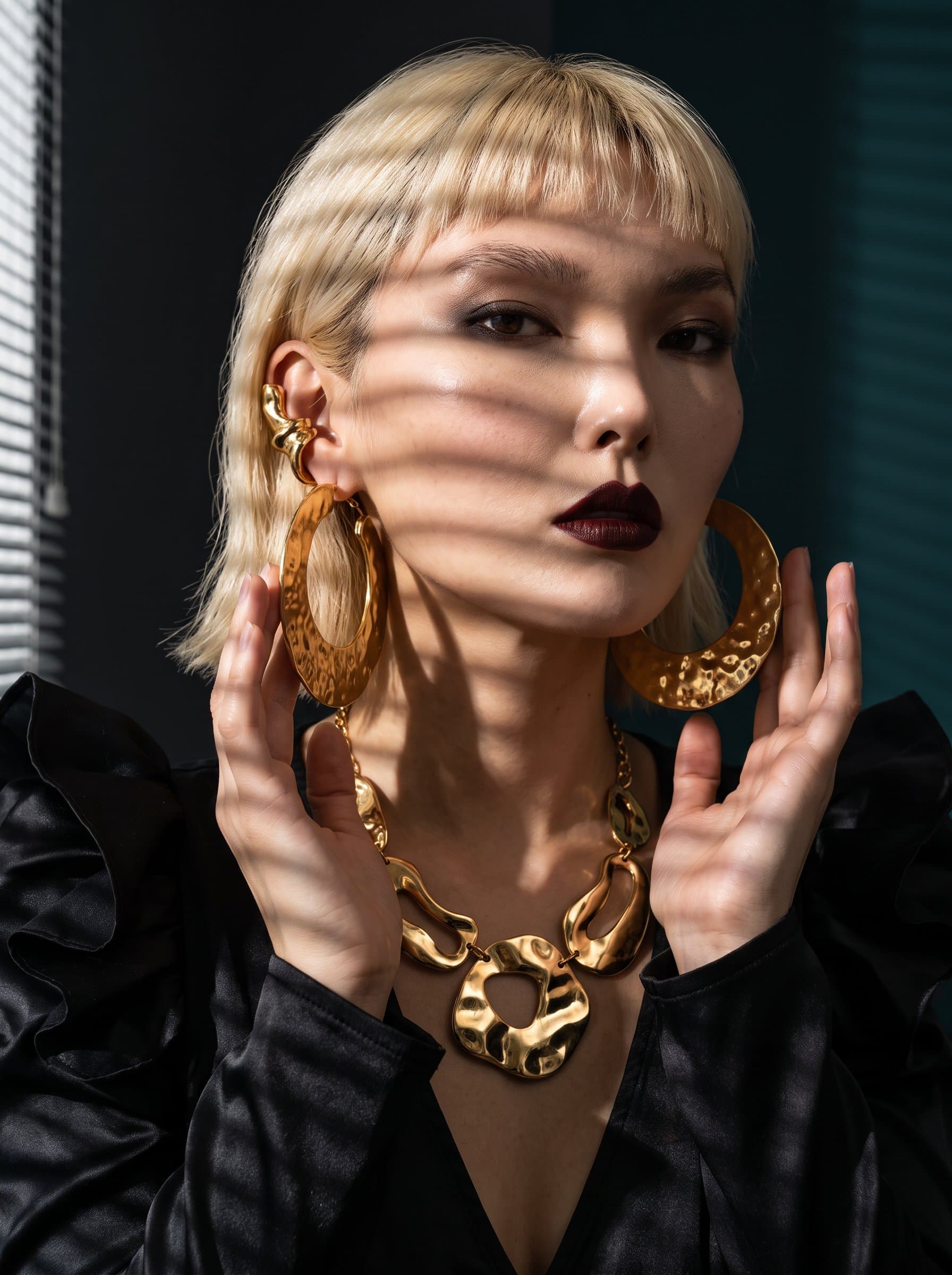: Produce an editorial AI headshot with an interplay of shadows and bold accessories, capturing the dramatic flair required for a high-impact beauty campaign.
