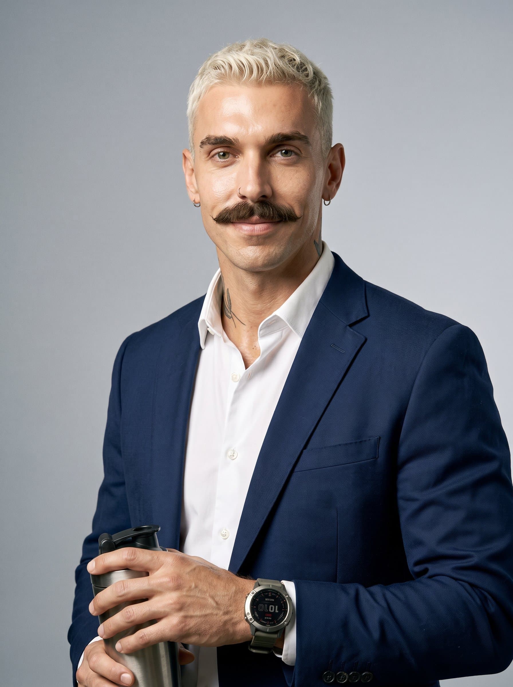 in a studio portrait with a subtle smile and direct eye contact, wearing classic professional attire combined with athletic accessories, bridging the worlds of corporate professionalism and active fitness.