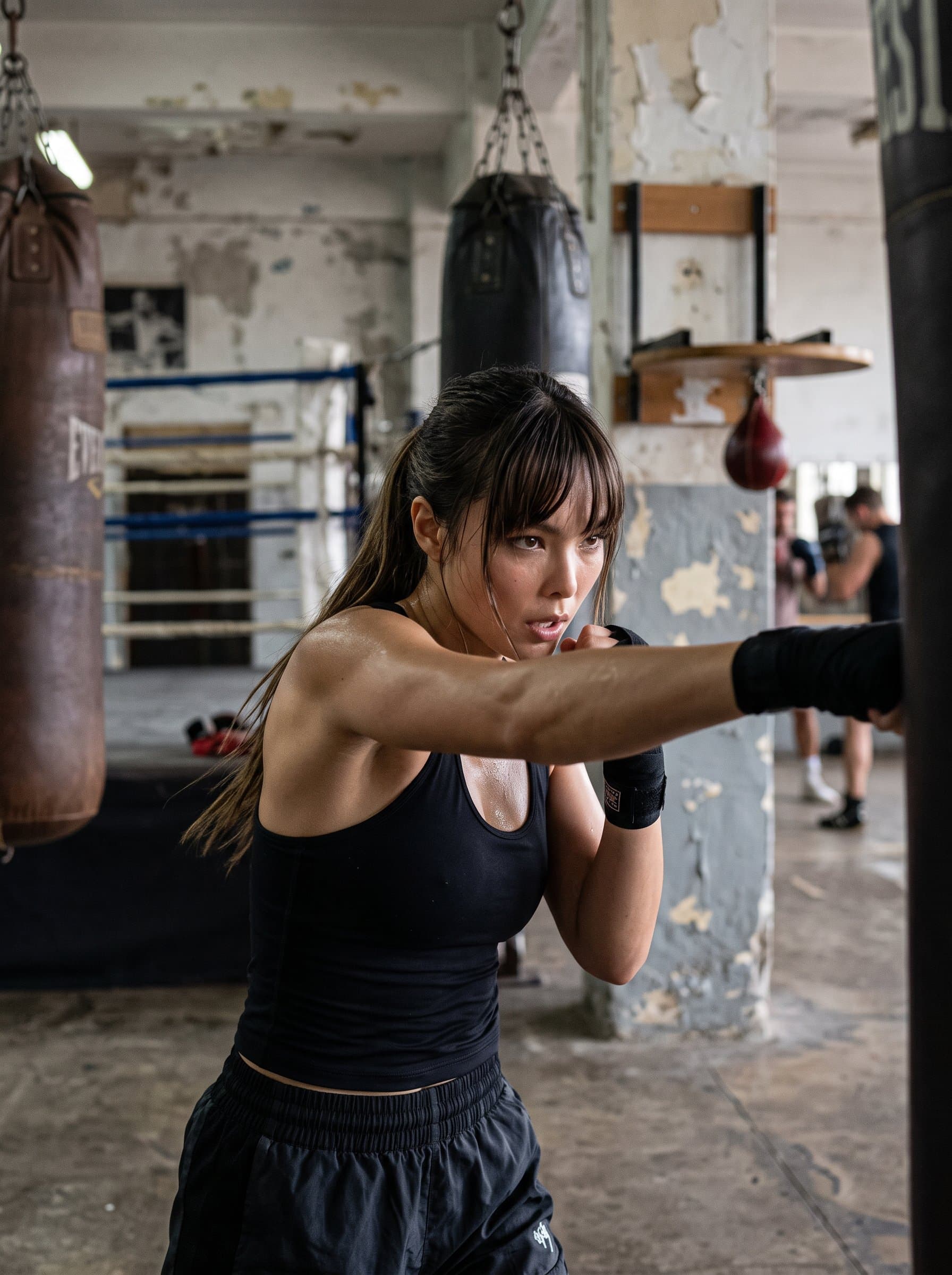 depicted in a boxing gym, shadowboxing with determination and powerful form, set against a gritty background, showcasing resilience, strength, and the fighter spirit in fitness.