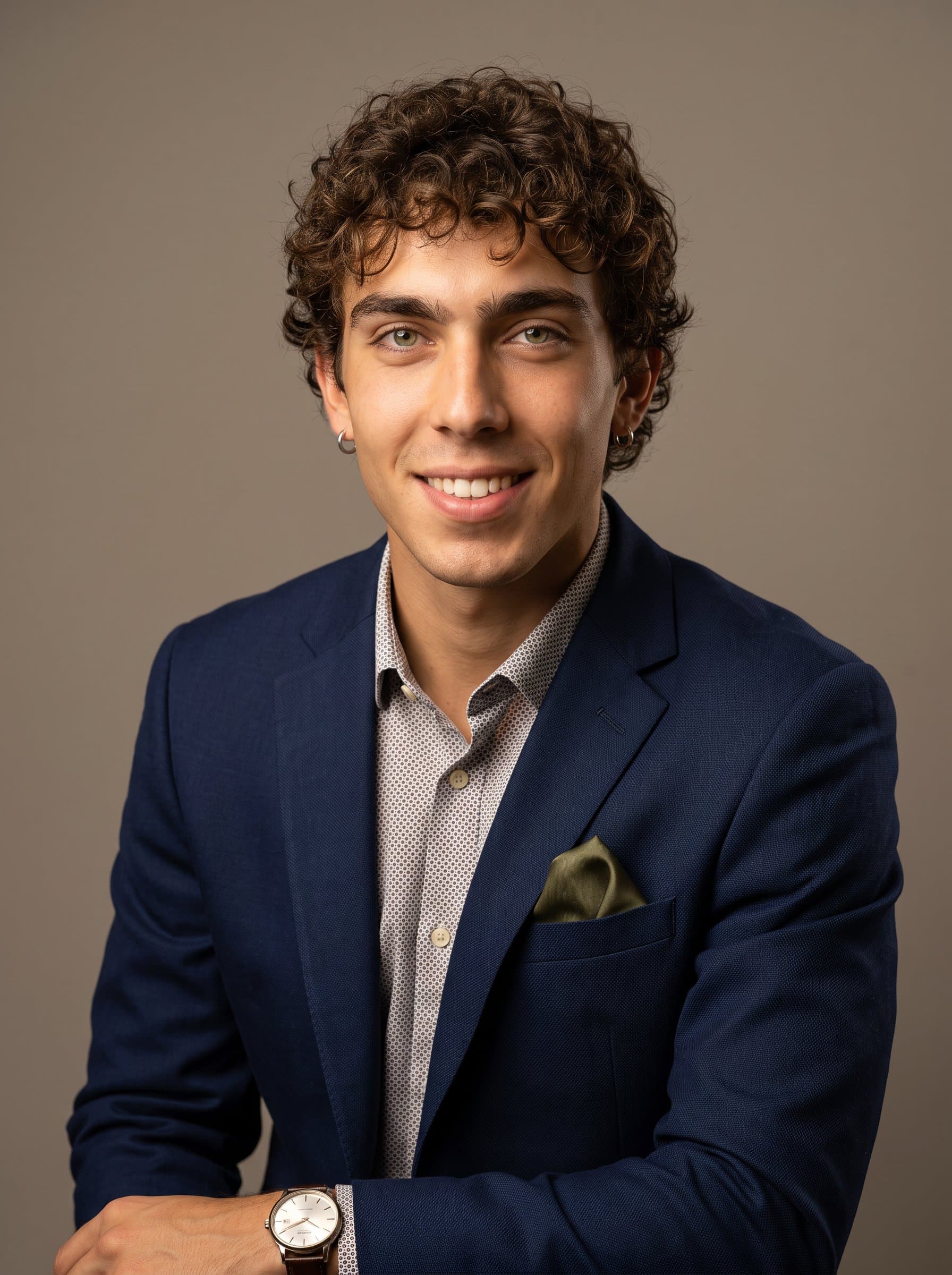 : Generate a headshot for a university faculty, showcasing professional attire with a hint of individuality. A neutral taupe background and warm, inviting light highlight their assured expression.