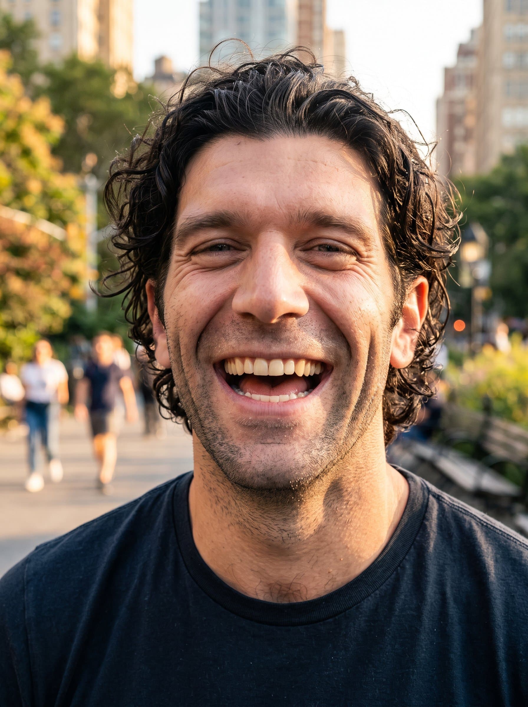 : Design an energetic headshot capturing a candid, laughter-filled moment. Use warm lighting and a bustling city park as the backdrop for an outgoing and personable social media persona.