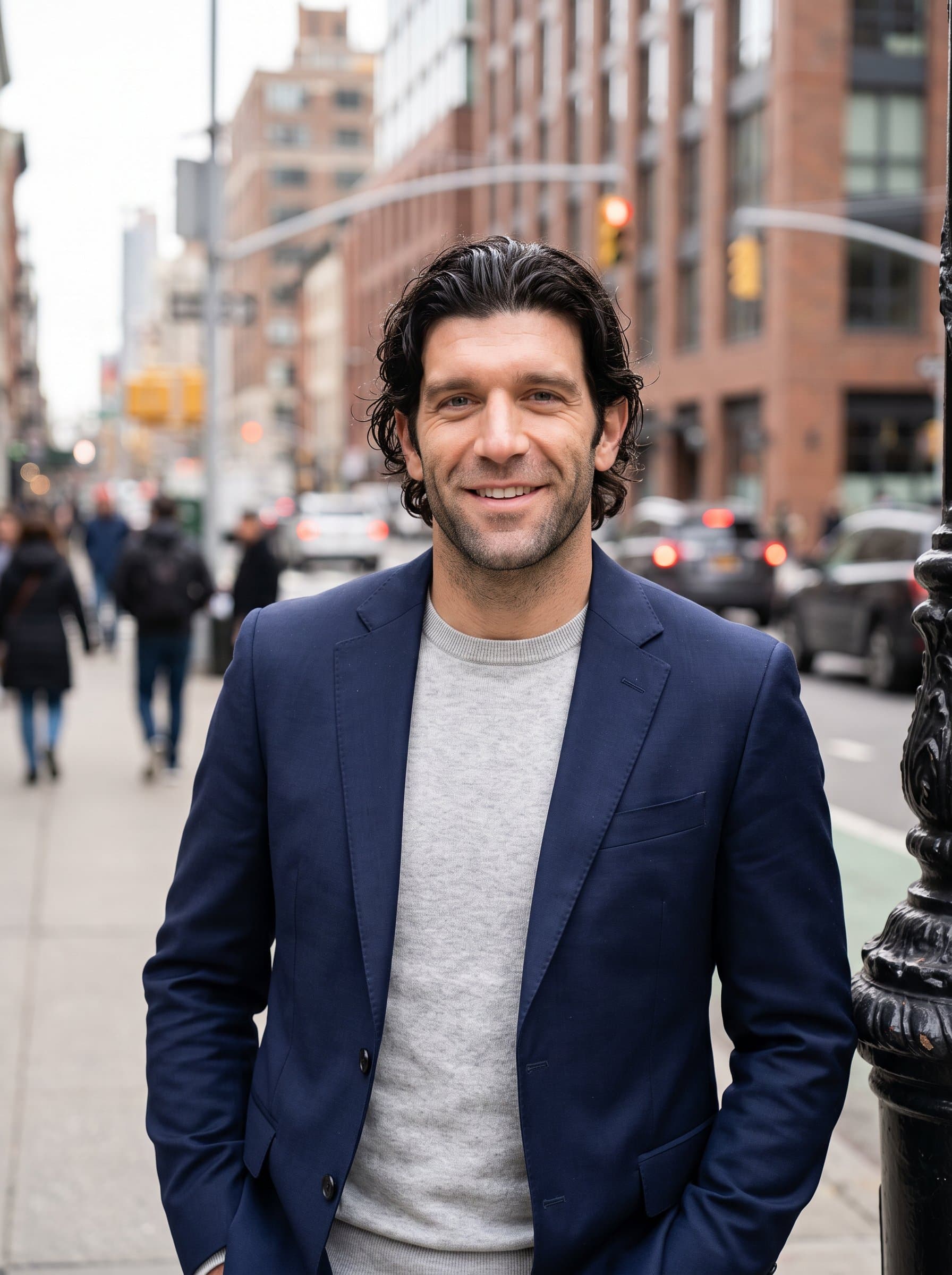 Design a portrait of an man wearing a well-fitted blazer. The setting should be an outdoor urban environment, with cityscape elements blurred to create a dynamic and approachable appearance.