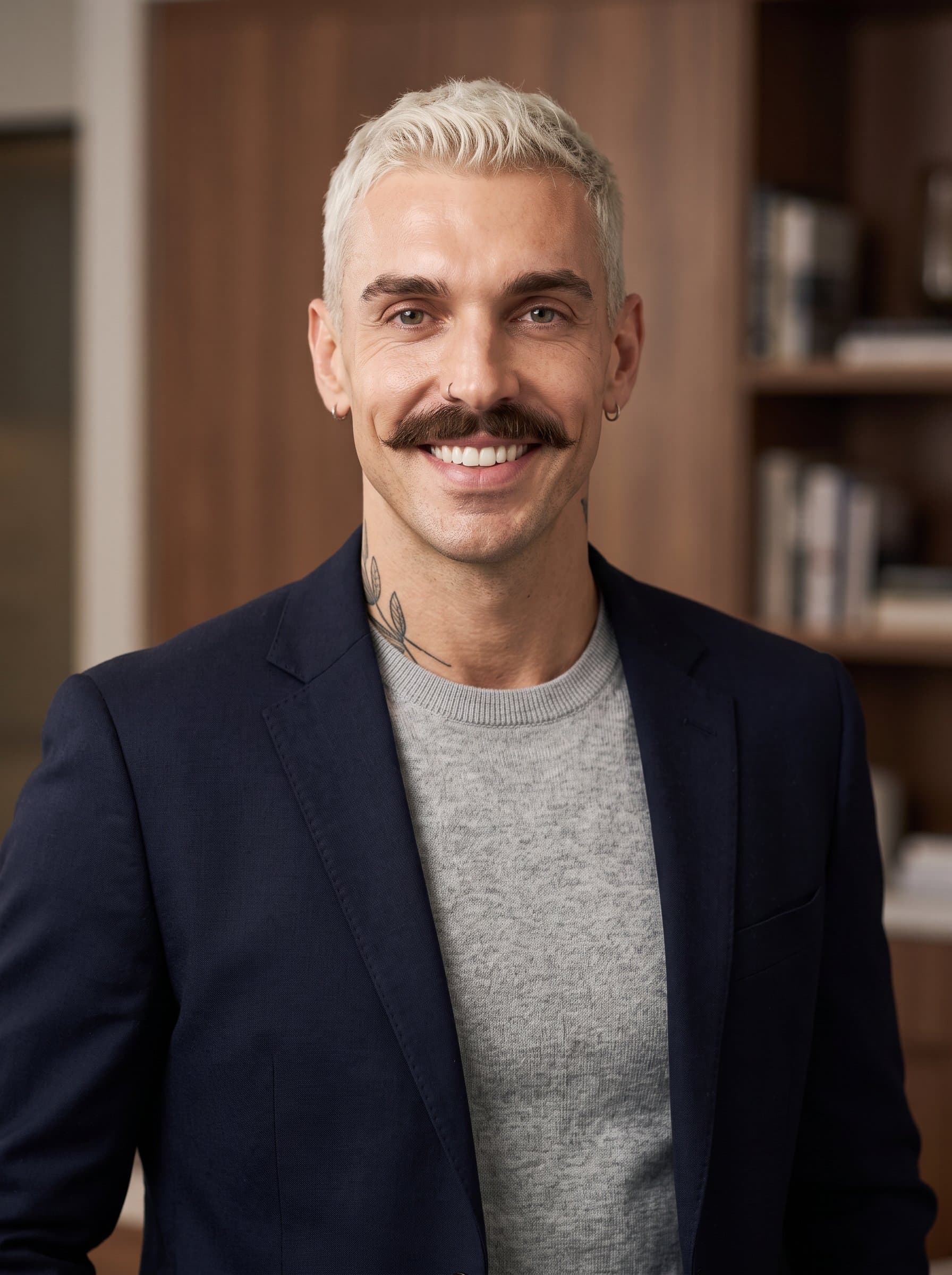 charismatic headshot featuring an man in smart-casual wear. The man’s confident smile is accentuated by the use of balanced lighting, making it an excellent choice for professional networking profiles.