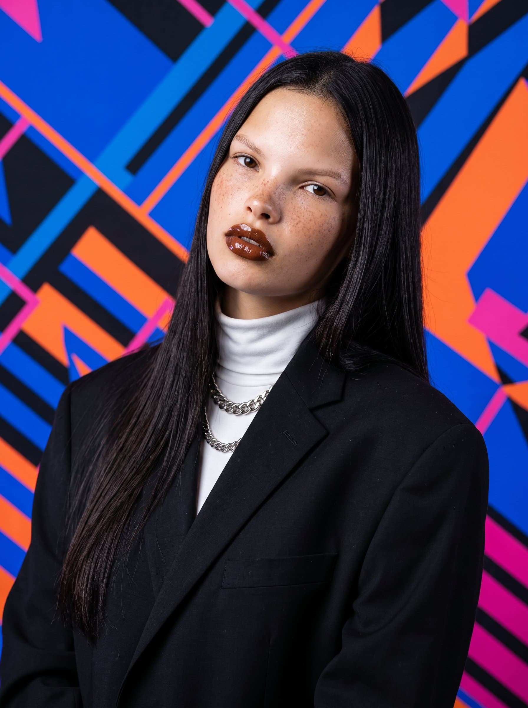 : Design a headshot featuring a dynamic geometric pattern as the background. The woman's pose is relaxed, in fashion-forward attire, conveying creativity and confidence for a modern Twitter aesthetic.