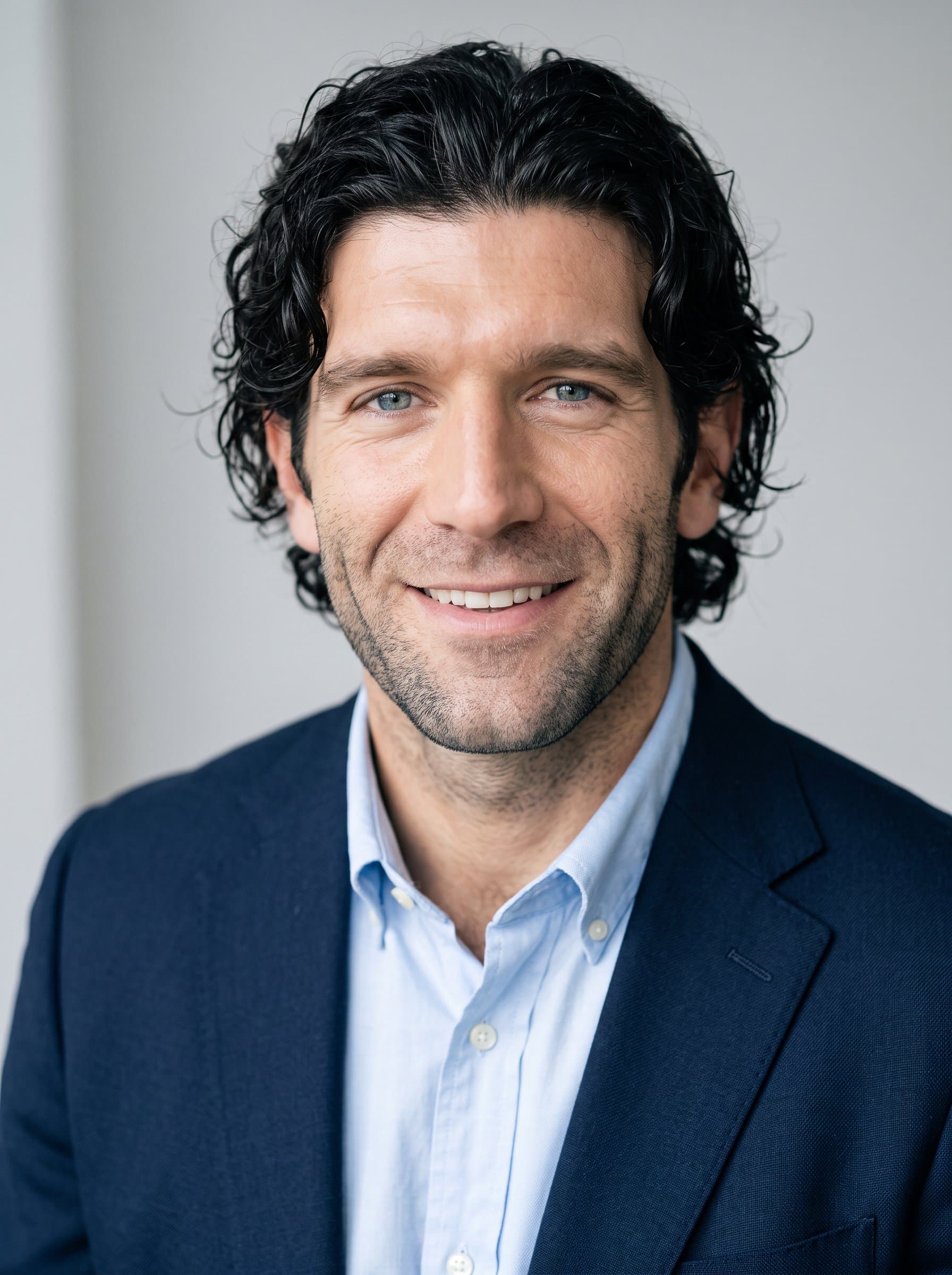 Capture a in a minimalist studio, with diffused lighting and a soft smile, emanating professionalism and warmth, ideal for an OkCupid profile image.