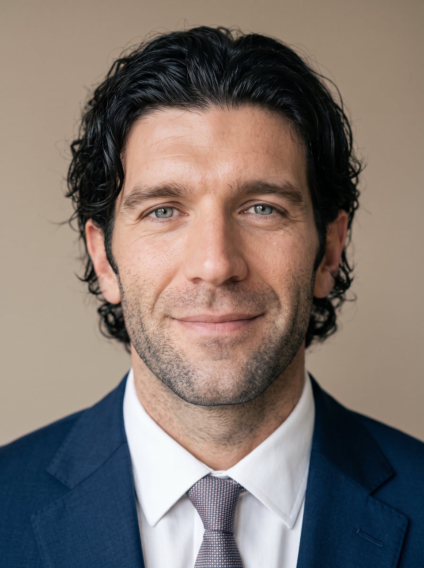 Create a portrait of an man facing forward, with a soft expression. The neutral beige background enhances the clarity of their eyes, conveying a sense of trust and professionalism.
