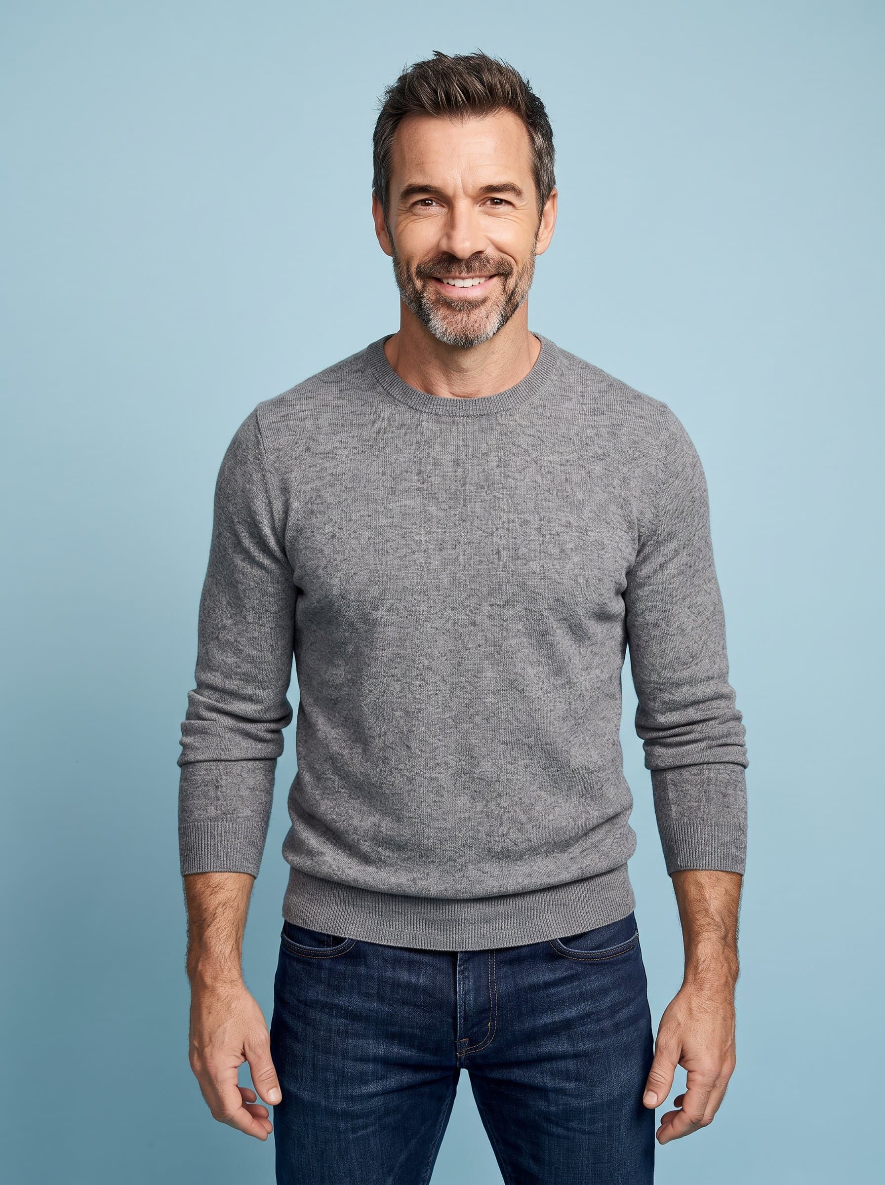 Illustrate a shot with a man wearing casual attire. Their relaxed shoulders and inviting smile against a pale blue backdrop exude a modern, approachable vibe suitable for online presence.