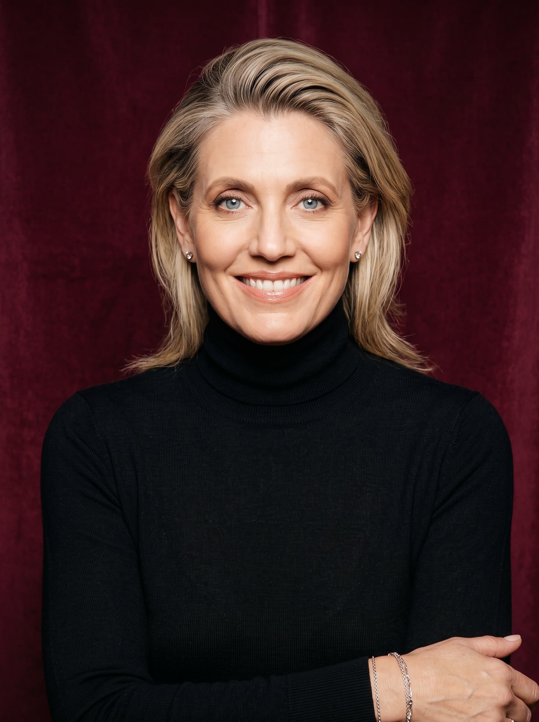 : Elegant headshot with a confident smile. Background: rich burgundy. Attire: sleek, black turtleneck. Add delicate silver accents for a touch of sophistication.