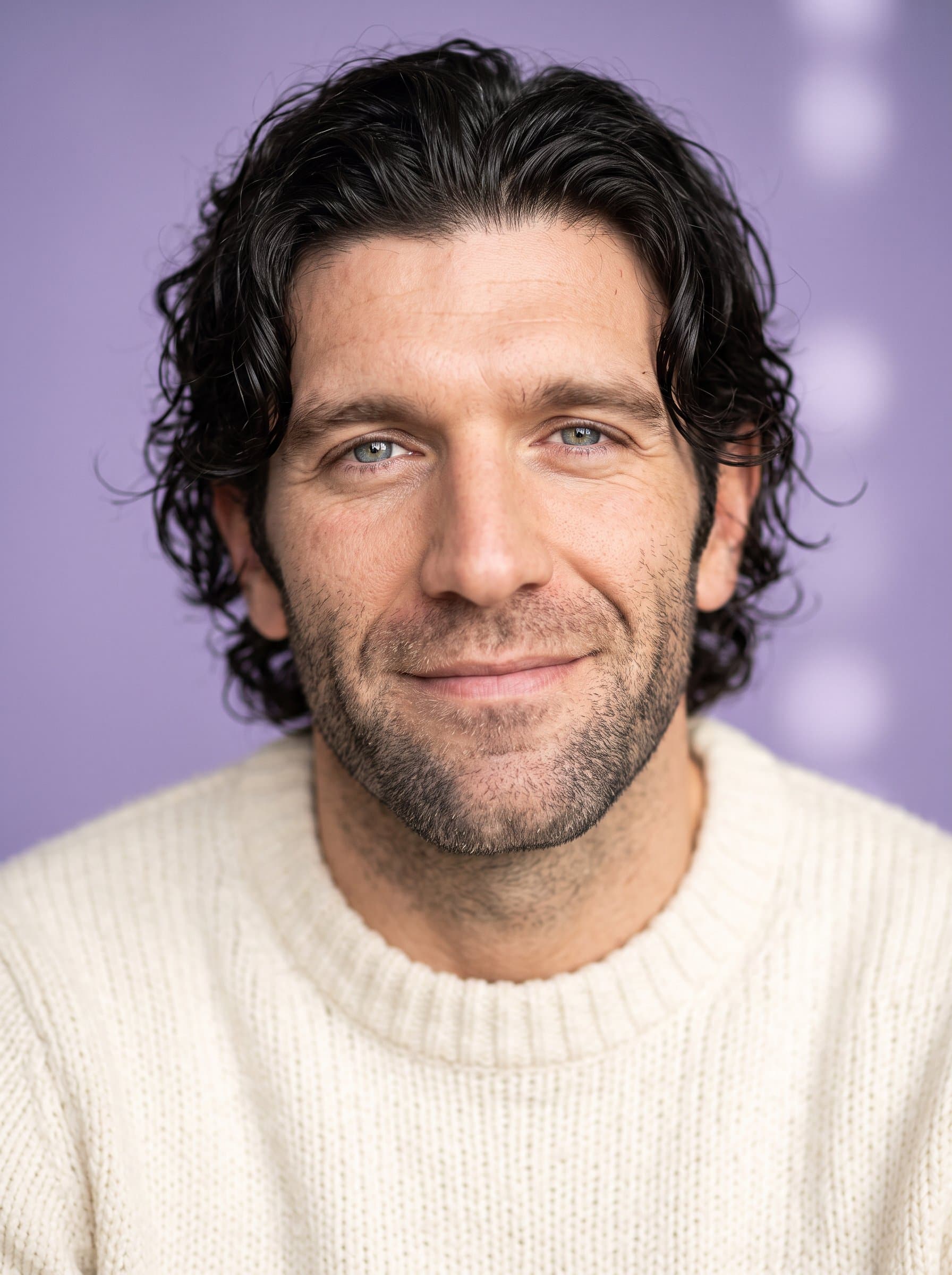 : Relaxed headshot with a gentle smile. Background: soft lavender. Attire: cozy, knitted sweater. Light up the eyes with a gentle sparkle for an inviting presence.
