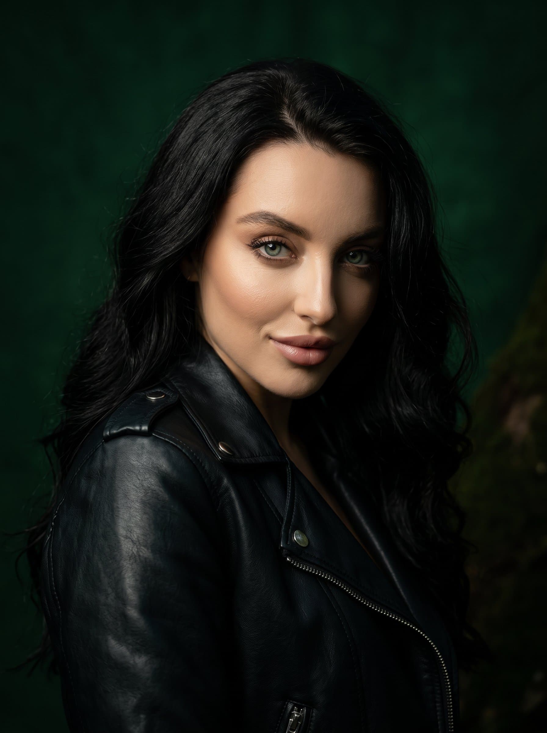 : Bold headshot with a confident smirk. Background: deep forest green. Attire: leather jacket. Add subtle shadow play for a dramatic effect.