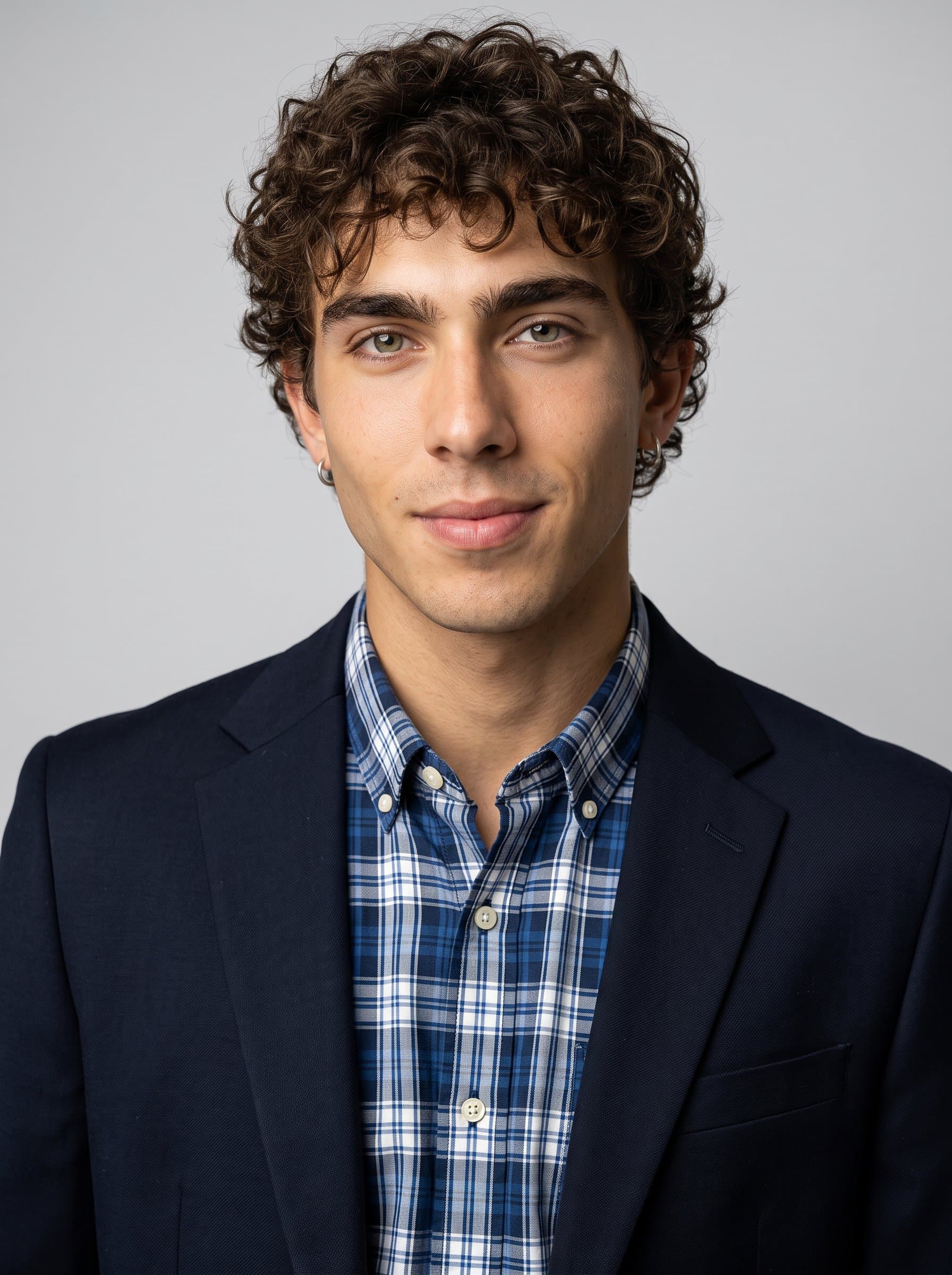 : Capture an aspiring medical hero in a classic plaid shirt under a dark blazer. The light gray background ensures a focus on professionalism and approachability, ideal for an ERAS headshot.