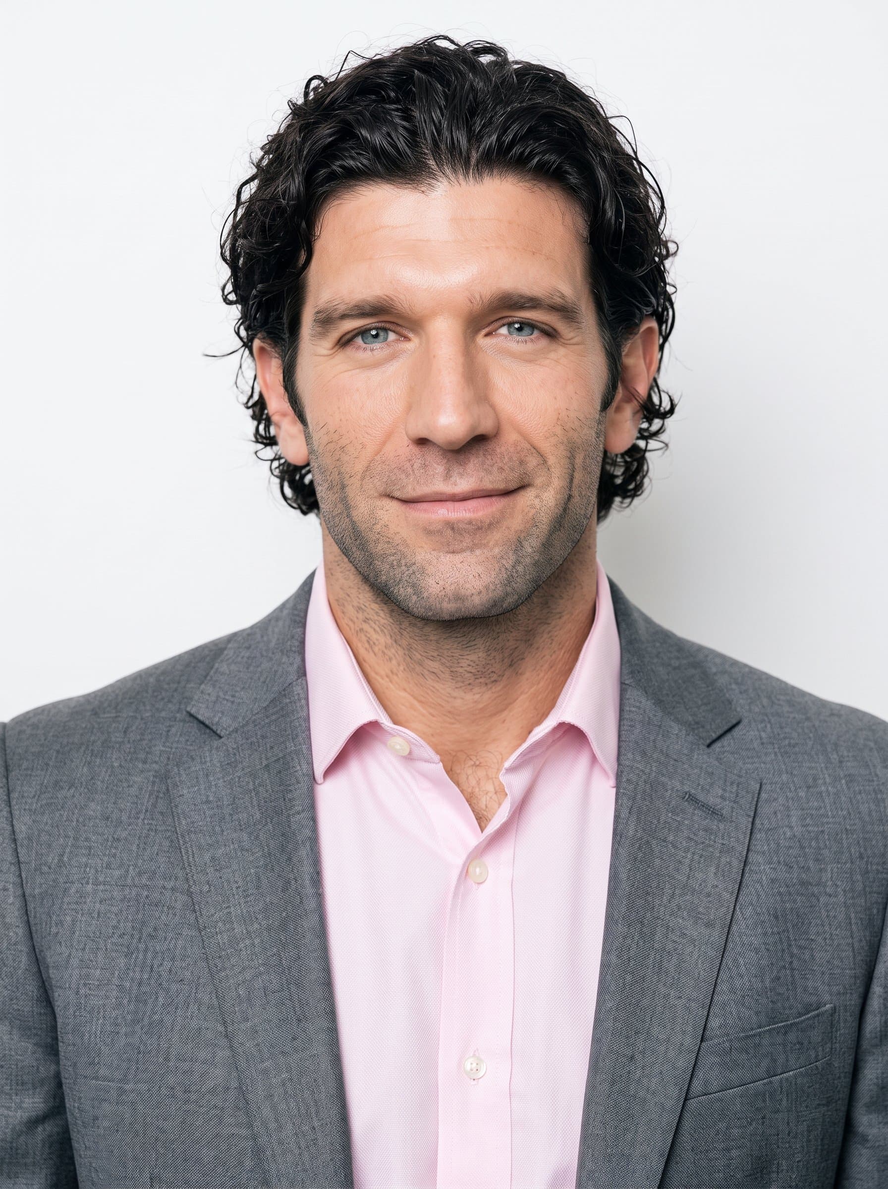 An ideal business image featuring with a confident man, showcasing a light pink blouse and a subtle smile. The background remains a flat, professional white.