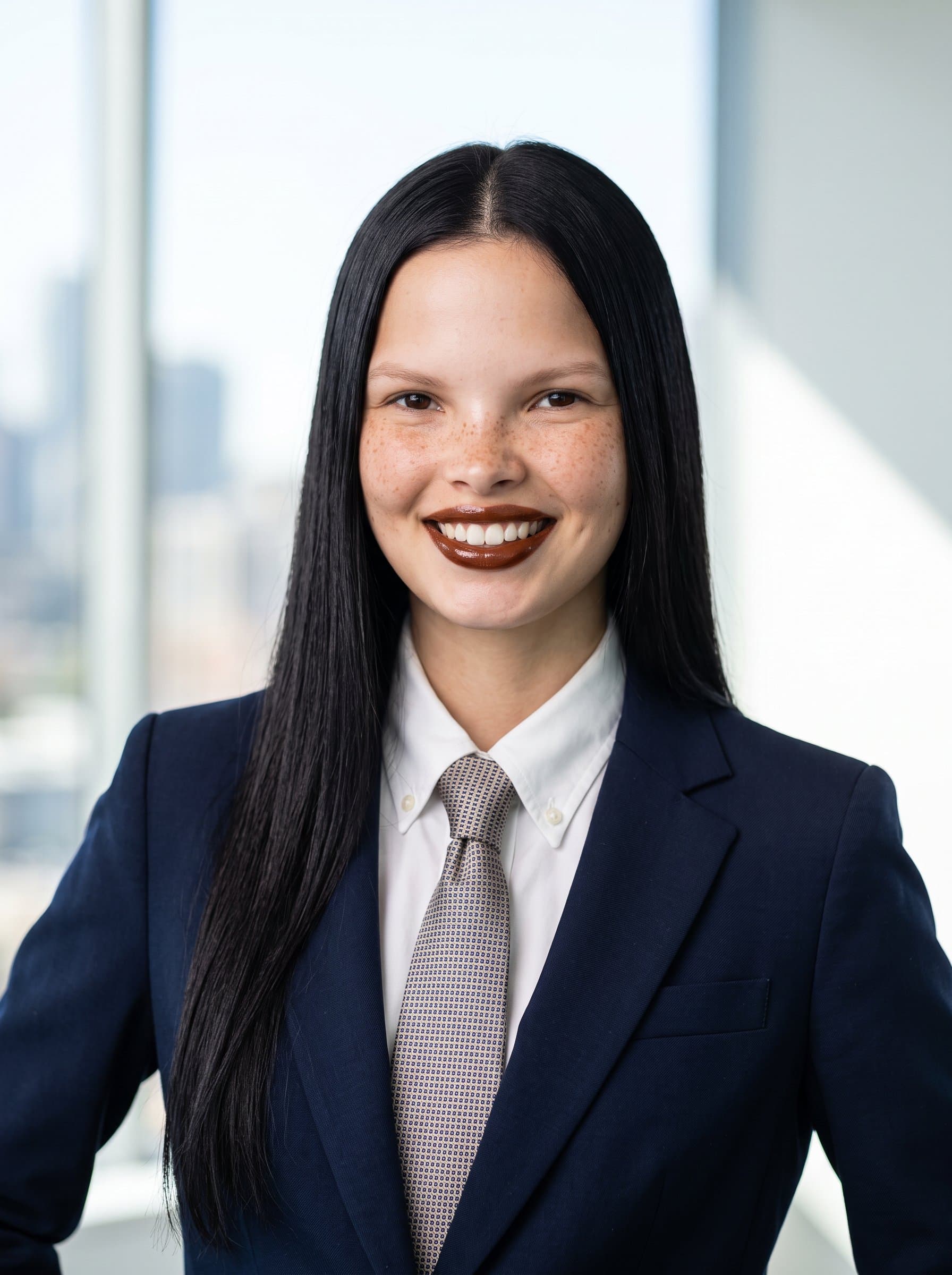portrayed in a tailored navy suit, with a subtle smile and bright lighting, creating a dynamic and approachable look for a standout business card.