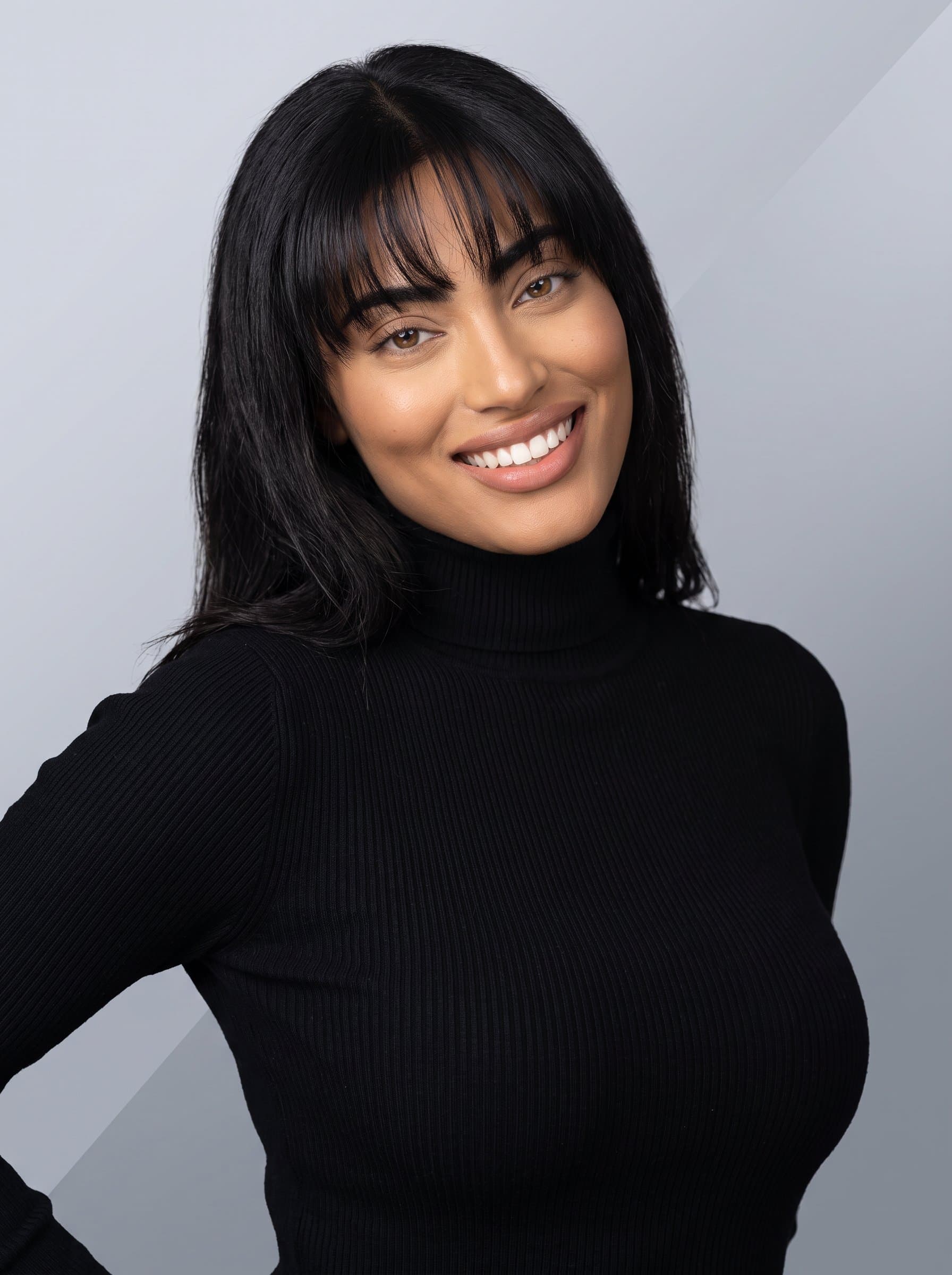 A dynamic and expressive AI headshot of dressed in a sleek black turtleneck, on a gradient grey background, intended for a contemporary business card style.