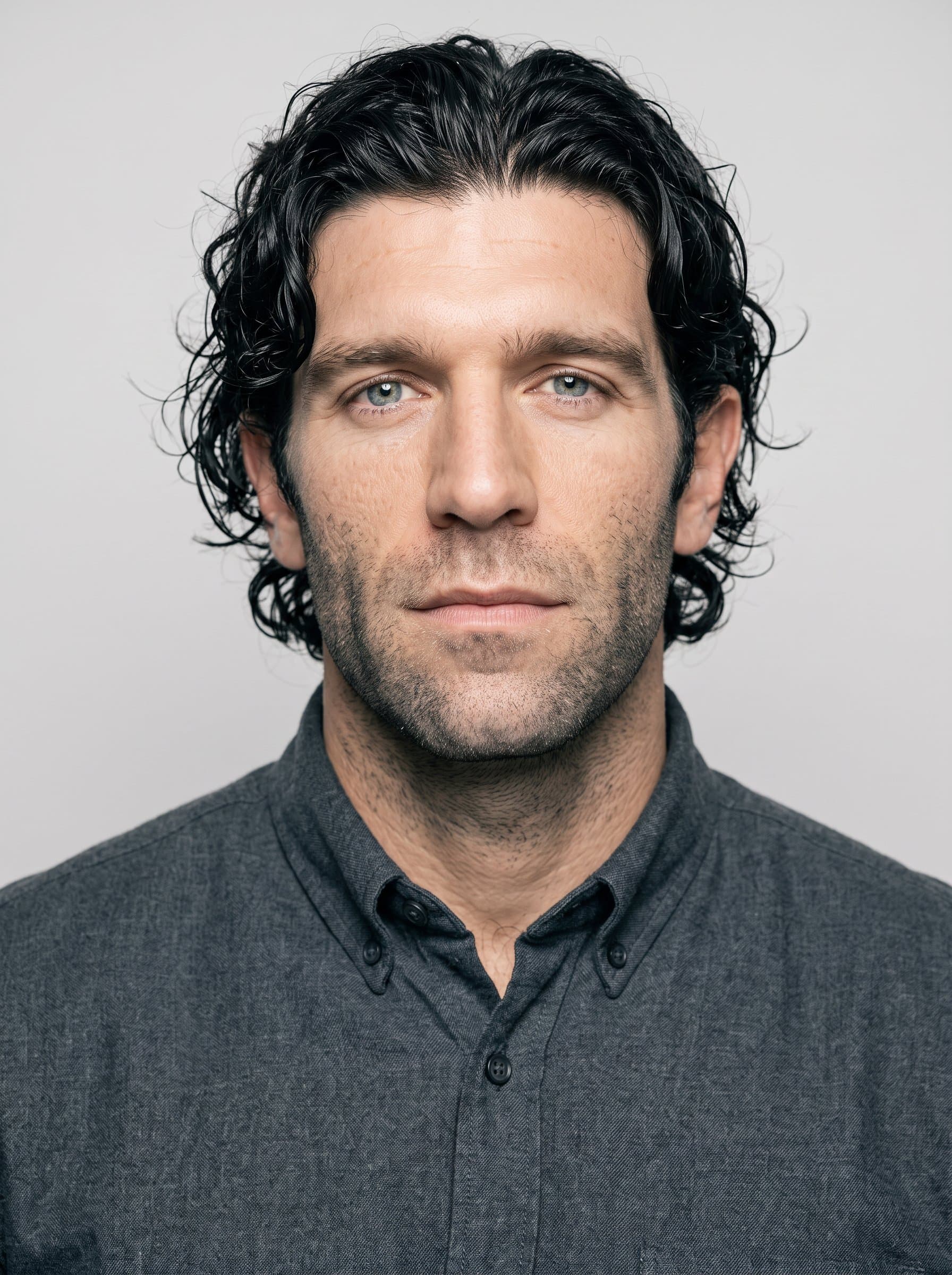 : Generate a crisp, professional headshot with AI expertise. The gender-neutral man is centered, with a neutral expression and a minimalist environment, suitable for a tech-driven workplace.